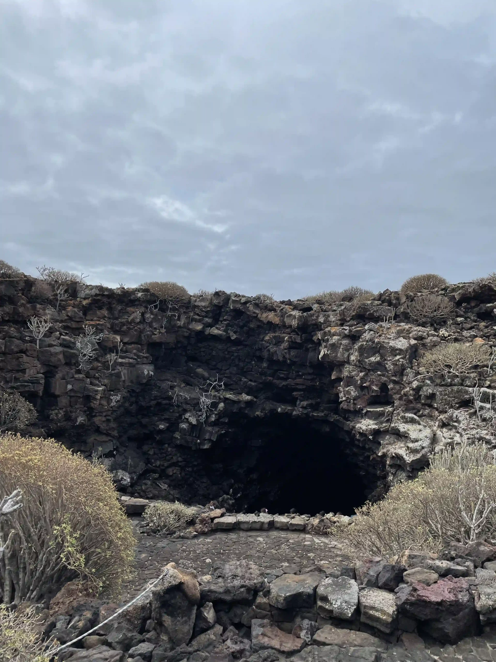 Entrada exterior y cartel de bienvenida a la Cueva de los Verdes con el malpaís volcánico al fondo, Foto propia La Maleta Inquieta, septiembre 2026