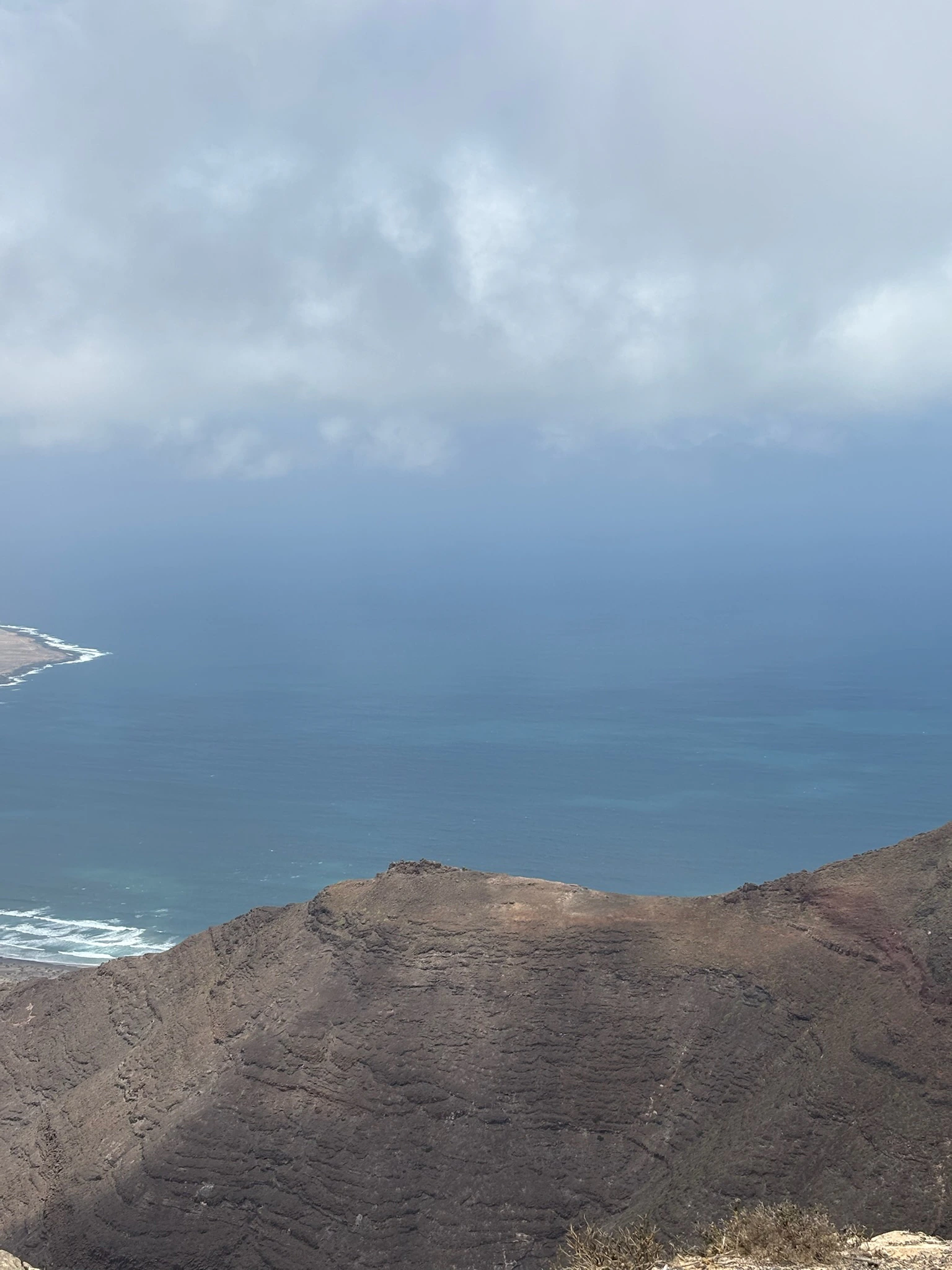 Playa de Famara con olas y el Risco al fondo, vista desde el mirador — Foto propia La Maleta Inquieta, mayo 2026