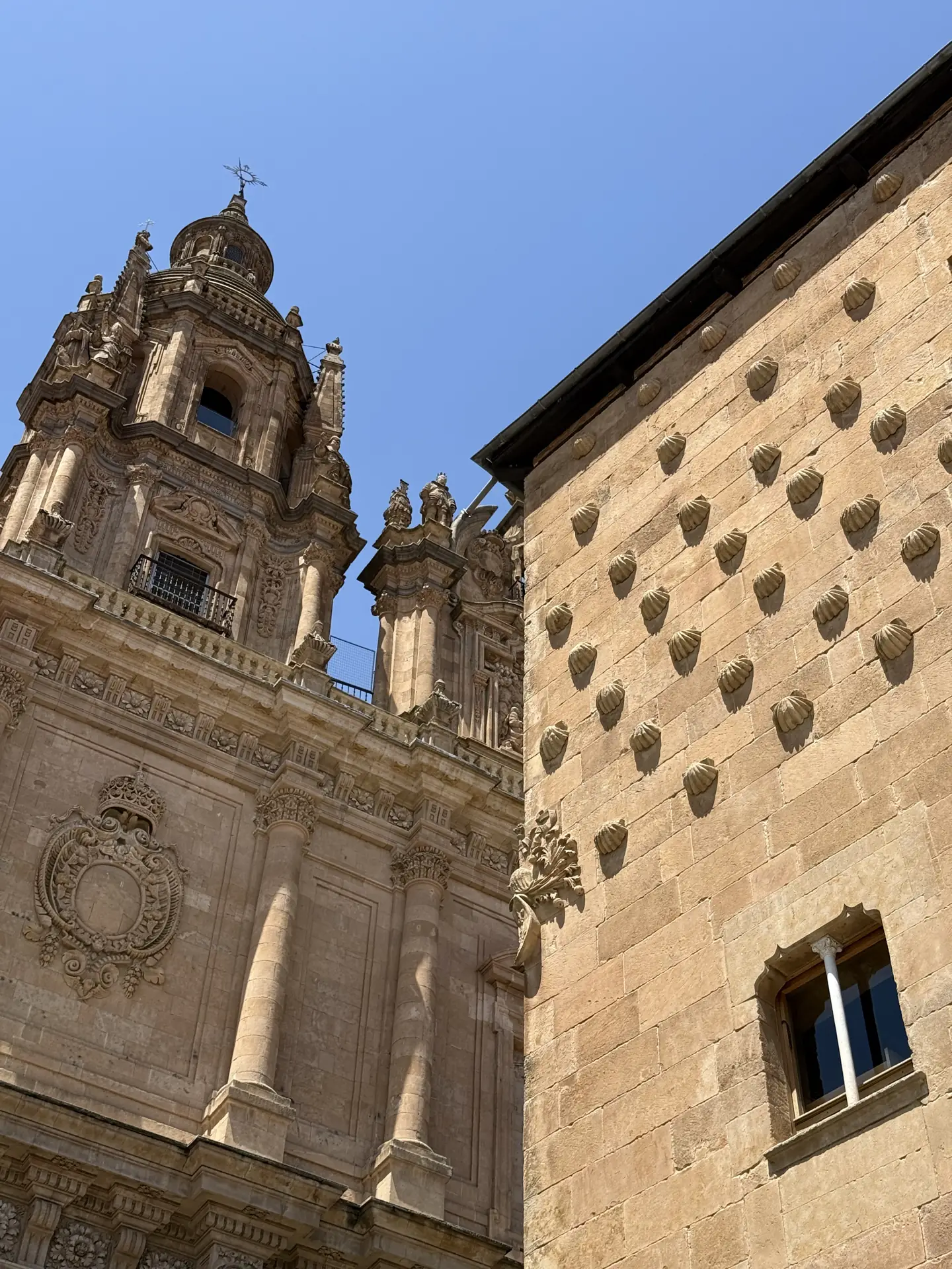 Fachada de la Casa de las Conchas con las conchas talladas y la torre de La Clerecía al fondo — Foto propia La Maleta Inquieta, junio 2026