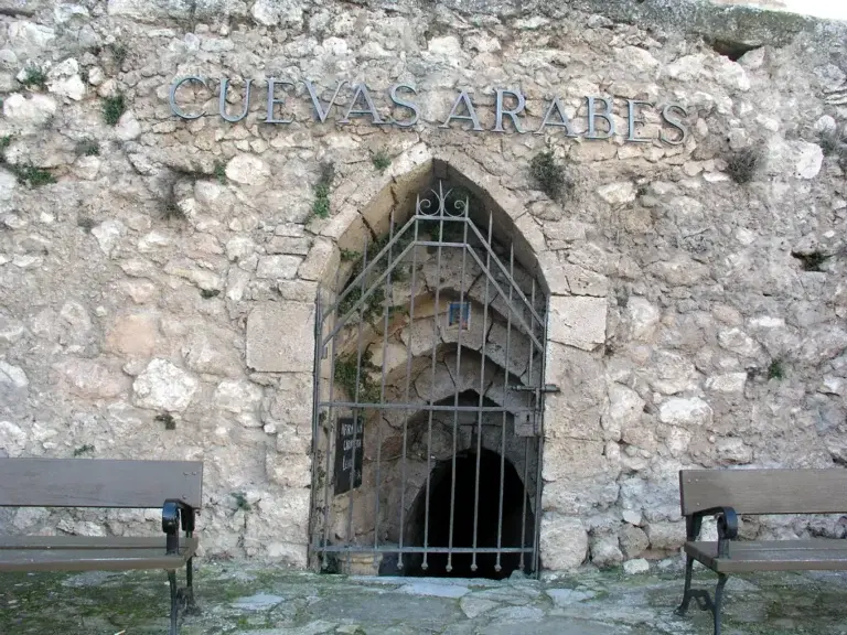 Entrada a las Cuevas Árabes de Brihuega con el rótulo tallado sobre el muro de piedra
