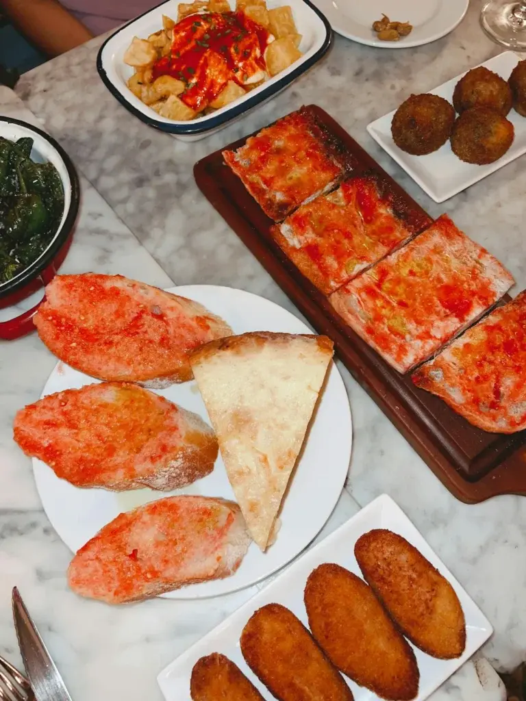 Surtido de tapas españolas con pan con tomate, patatas bravas y croquetas