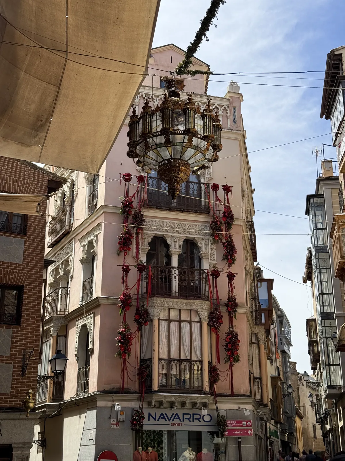 Fachada de Toledo engalanada con guirnaldas y colgaduras rojas y un gran farol durante el Corpus — Foto propia La Maleta Inquieta, junio 2026