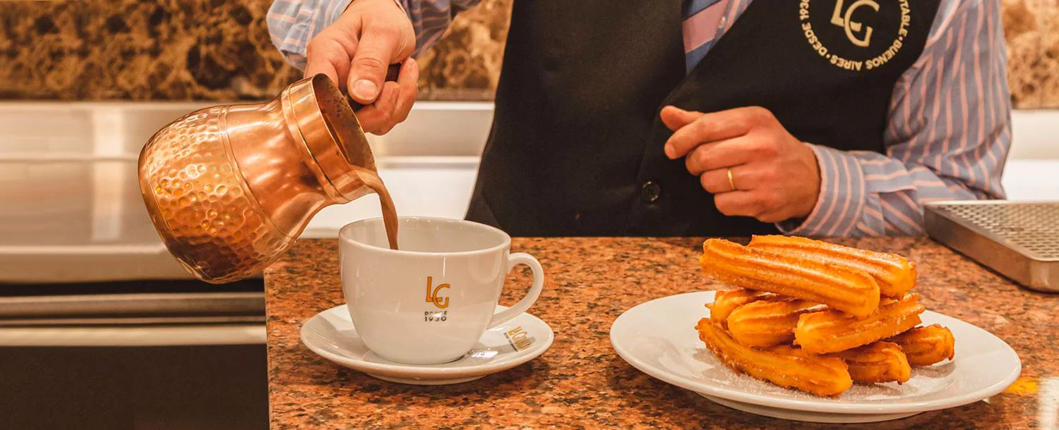 Churros recién fritos espolvoreados con azúcar sobre un plato en una chocolatería madrileña. Foto propia La Maleta Inquieta, julio 2026