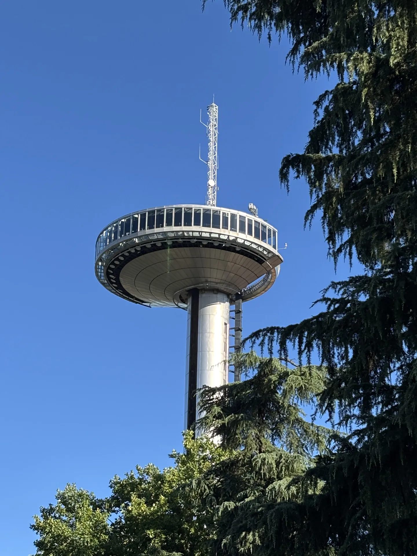 La torre mirador del Faro de Moncloa de Madrid recortada contra el cielo, con su cabeza acristalada en lo alto.