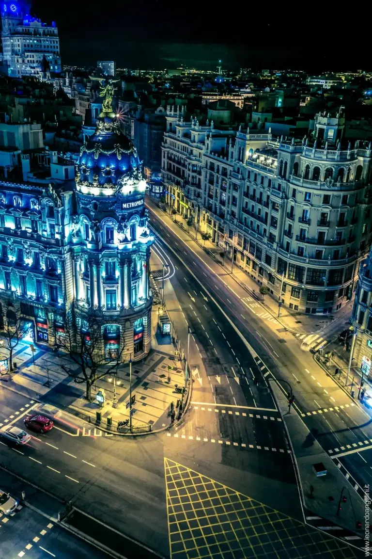 Gran Vía de Madrid de noche con el Edificio Metrópolis iluminado y la avenida al fondo con estelas de luz