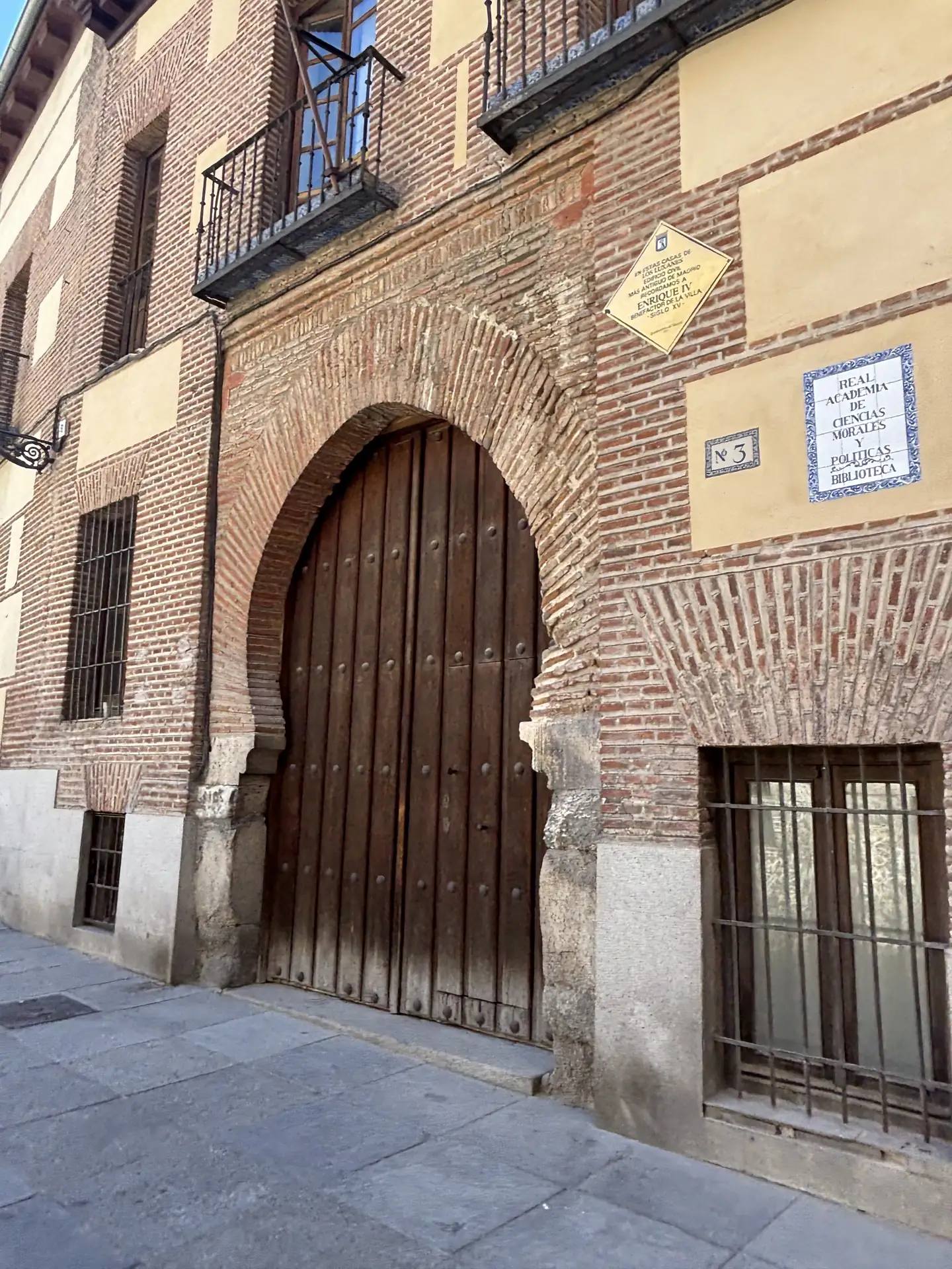 Portada de ladrillo con arco y puerta de madera junto a la placa de la Real Academia de Ciencias Morales y Políticas, en el Madrid de los Austrias. Foto propia La Maleta Inquieta, septiembre 2026
