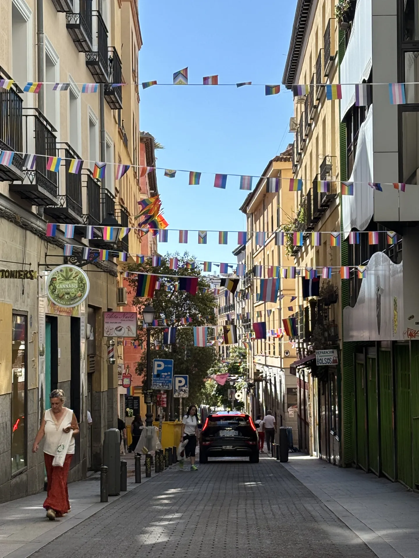 Calle del barrio de Chueca en Madrid de noche, decorada con banderas arcoíris. Foto propia La Maleta Inquieta, julio 2026