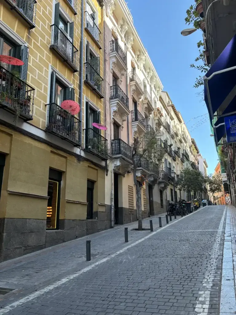 Calle típica de Malasaña con decoración de paraguas colgantes — Foto propia La Maleta Inquieta, julio 2026