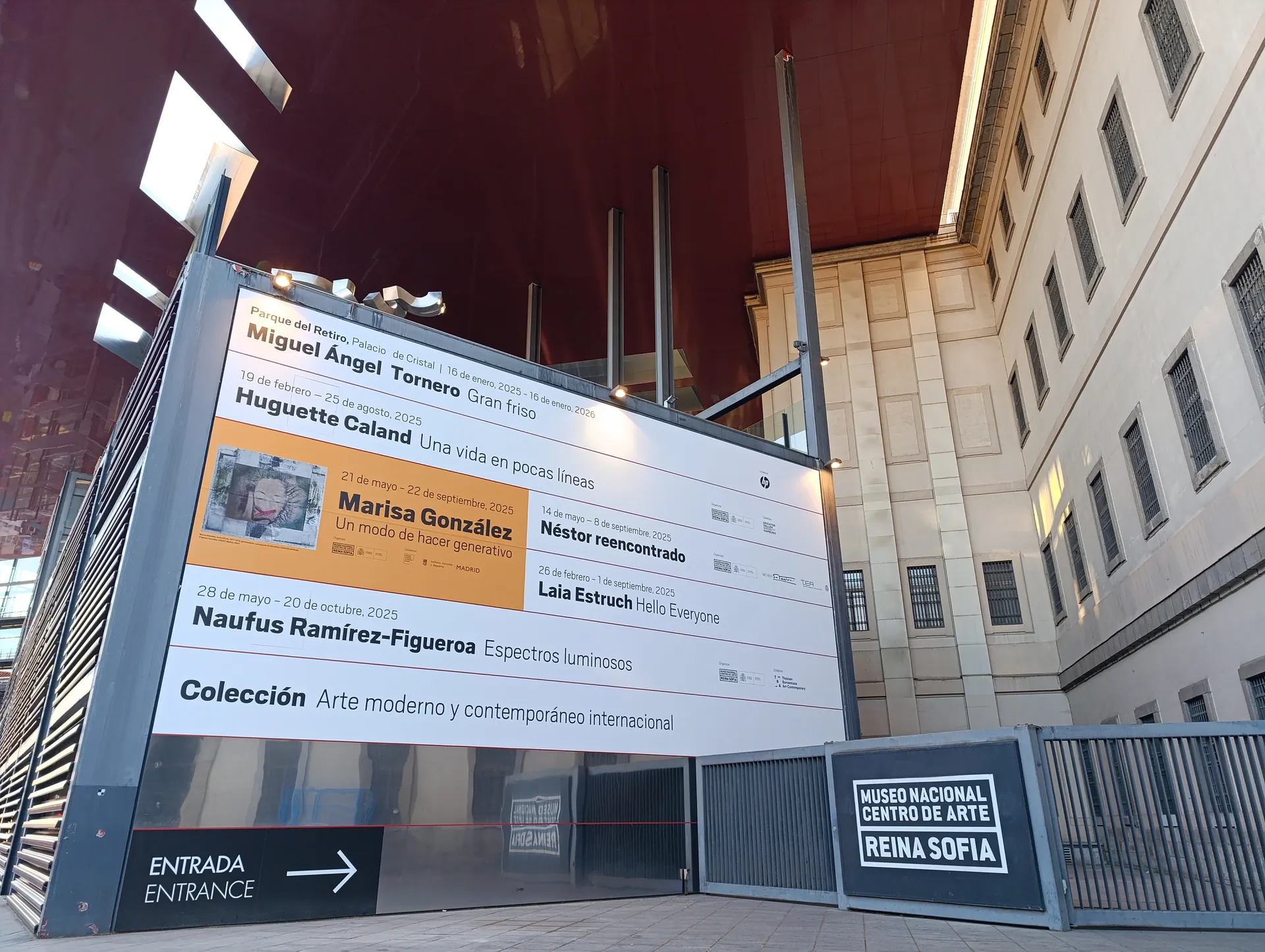 Entrada del Museo Reina Sofía, en Madrid, con el panel de exposiciones y el cartel del museo junto al edificio