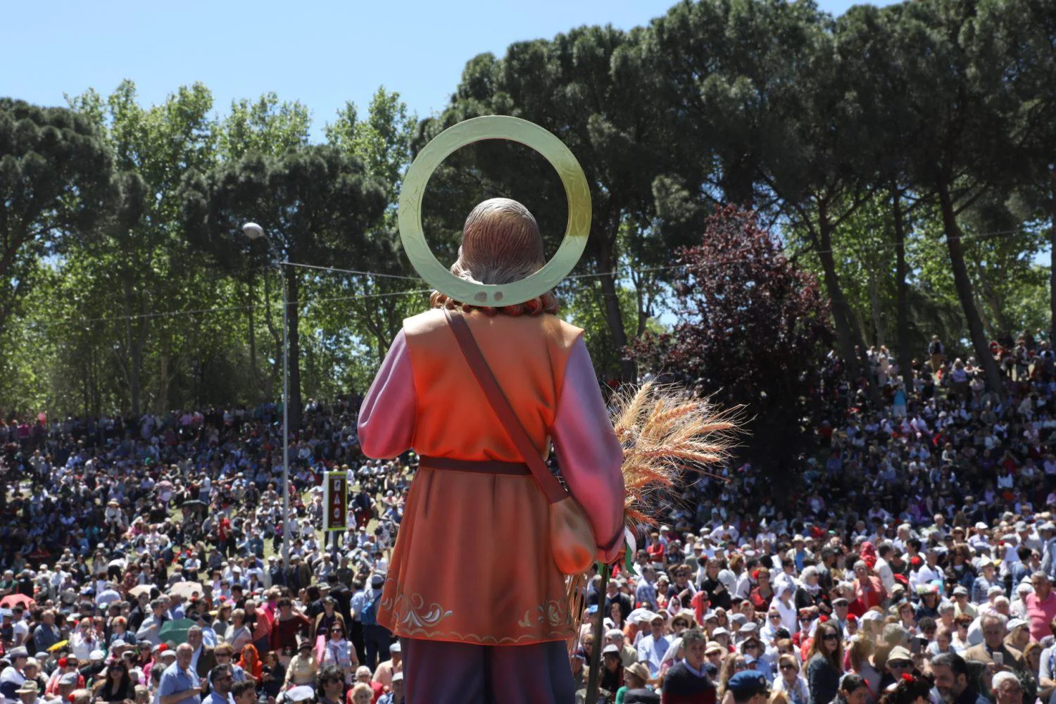 Figura de San Isidro Labrador ante una multitud durante la romería de las fiestas de Madrid