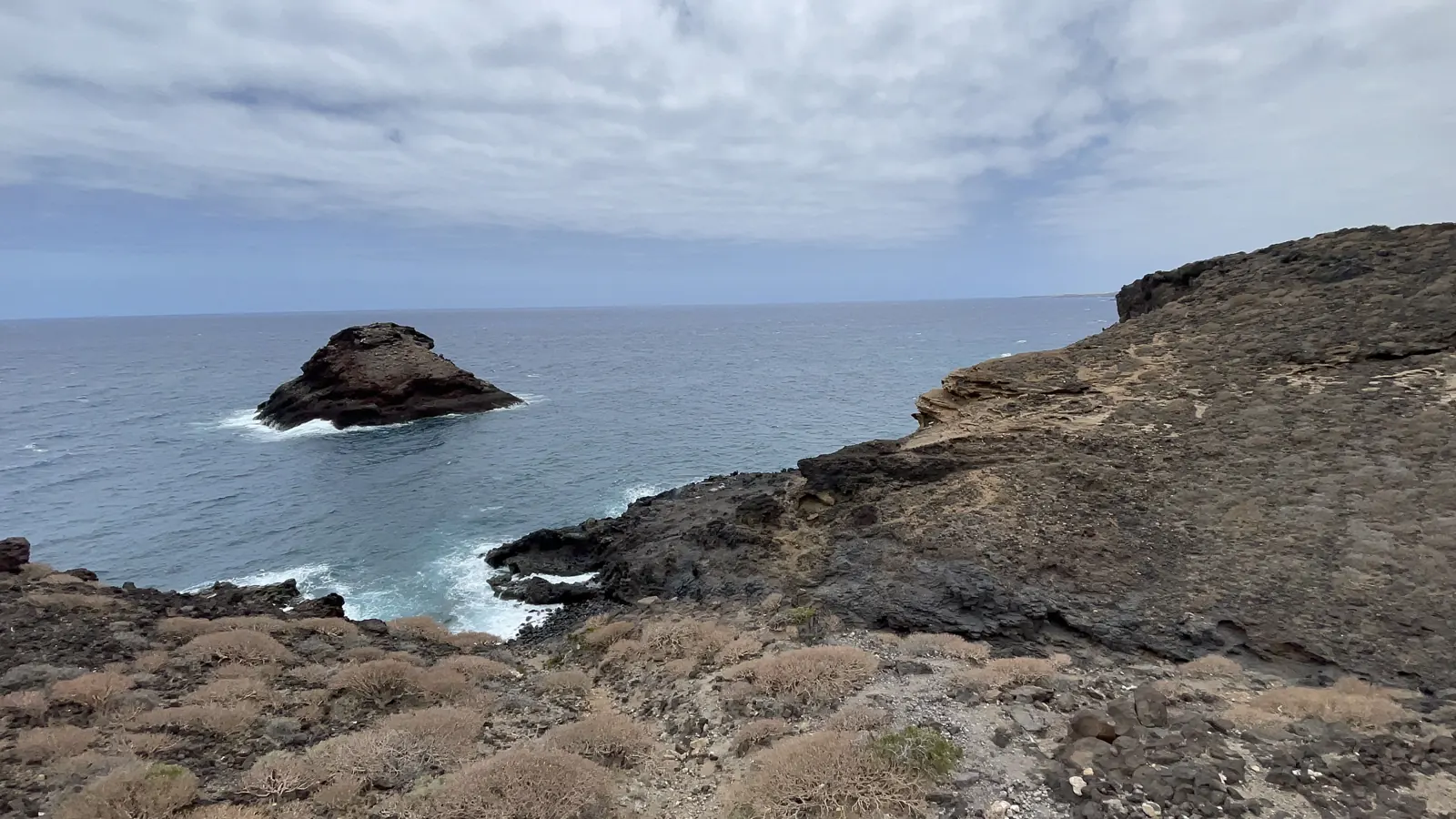 Costa rocosa volcánica con islote en el mar turquesa del Puertito de Güímar. Foto propia La Maleta Inquieta, agosto 2026.