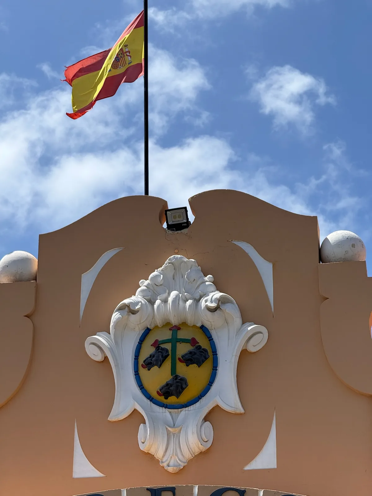 Escudo de Santa Cruz de Tenerife junto a la bandera de España en el centro de la ciudad, cerca de la estación marítima. Foto propia La Maleta Inquieta, agosto 2026