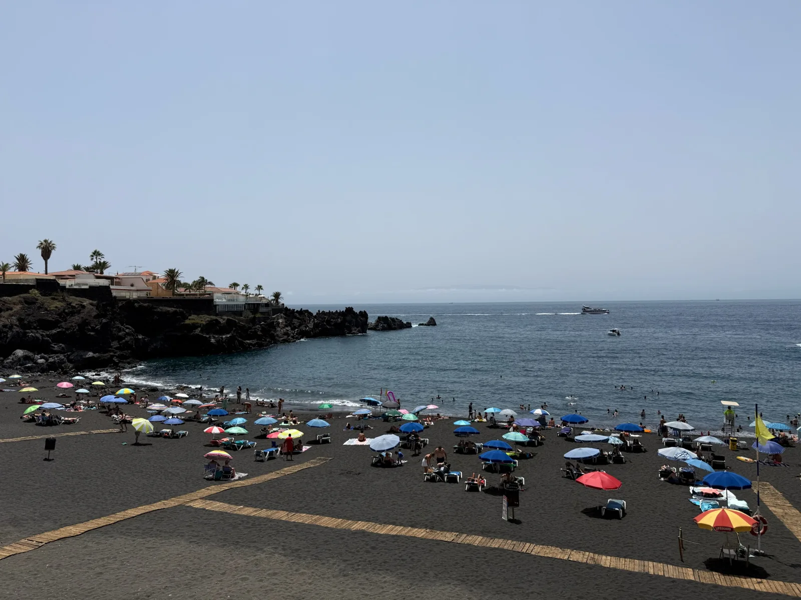 Playa de arena negra volcánica con sombrillas de colores en el sur de Tenerife. Foto propia La Maleta Inquieta, agosto 2026.