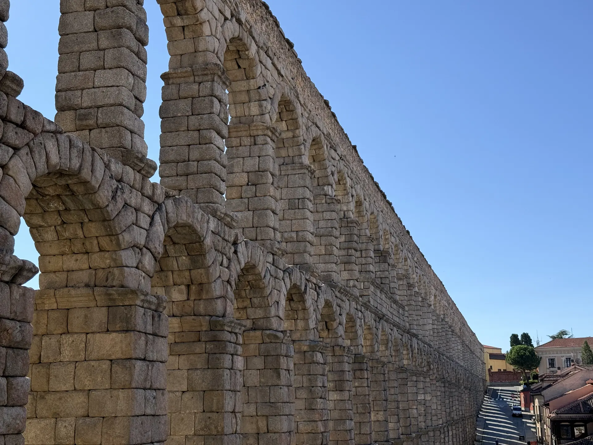 Los arcos del Acueducto de Segovia vistos de lado, con la hilera perdiéndose calle abajo. Foto propia La Maleta Inquieta, septiembre 2026.