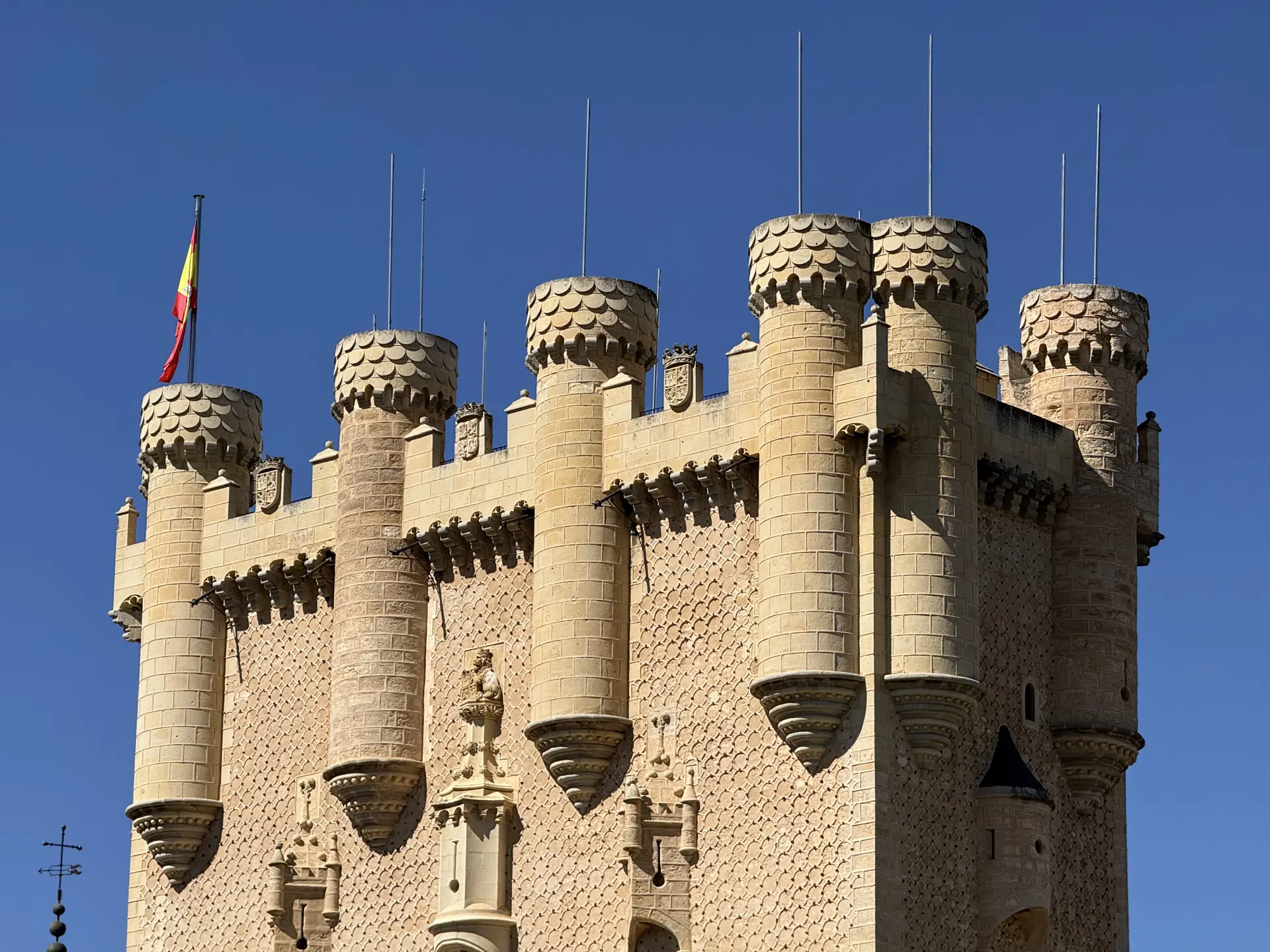 Detalle de torres cilíndricas del Alcázar con chapiteles de pizarra en escamas y bandera española, Foto propia La Maleta Inquieta, octubre 2026