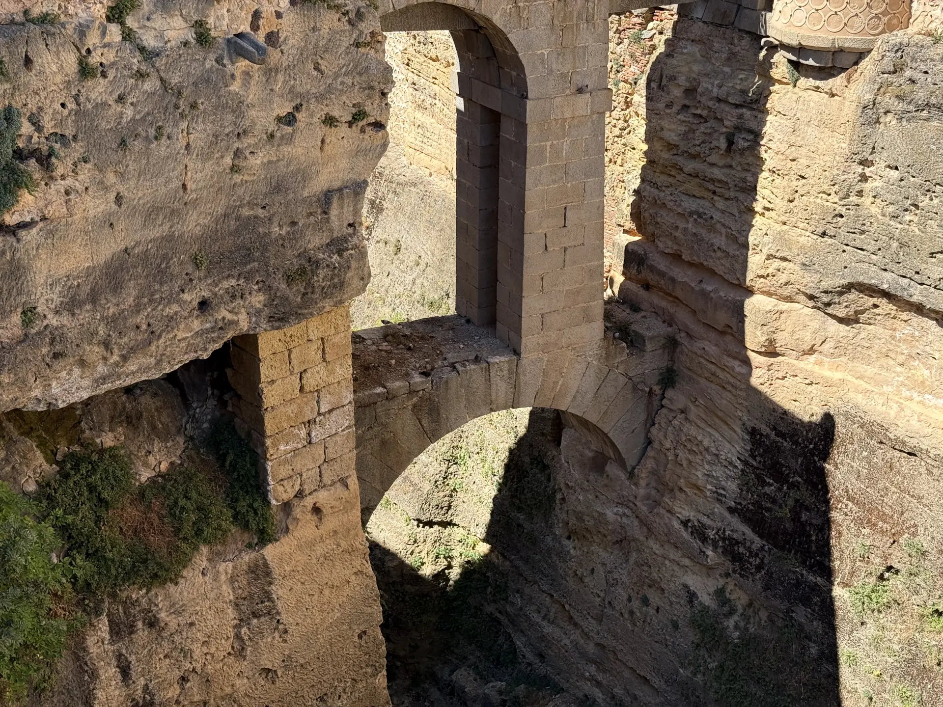 Vista cenital del foso y las murallas del Alcázar de Segovia, con un arco de piedra y los muros defensivos. Foto propia La Maleta Inquieta, septiembre 2026.