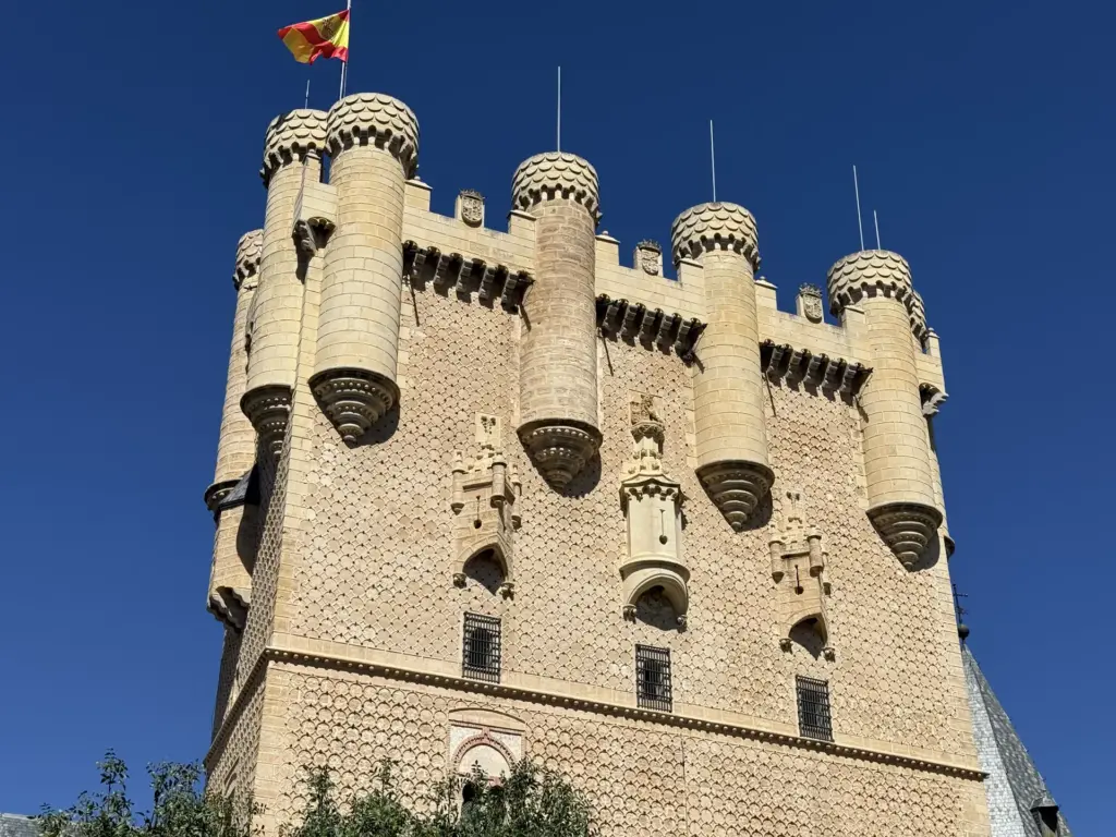 Torre del Homenaje del Alcázar en contrapicado con bandera española y chapiteles escamosos — Foto propia La Maleta Inquieta, septiembre 2026