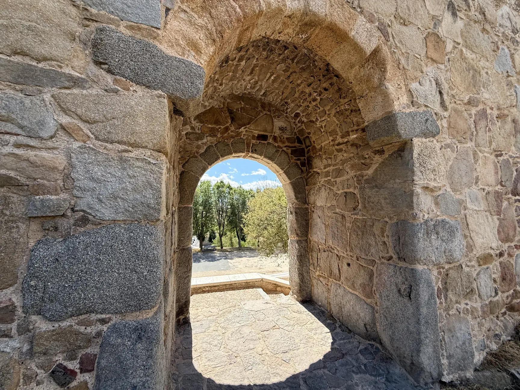 Arco de la Malaventura, postigo peatonal de la muralla sur de Ávila, visto desde dentro con la arboleda al fondo. Foto propia La Maleta Inquieta, septiembre 2026