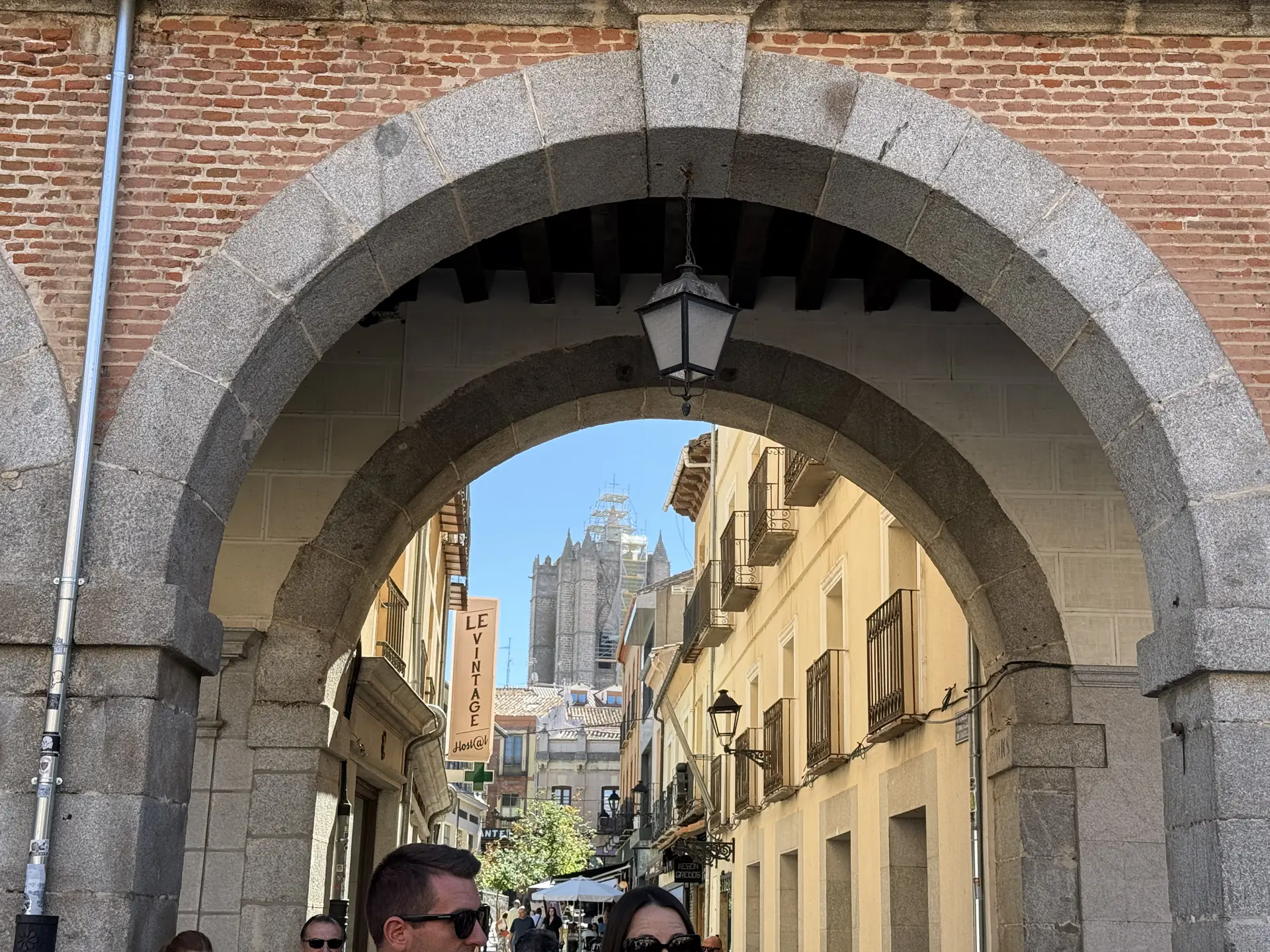 Arco de salida del Mercado Chico de Ávila hacia una calle peatonal con la torre de la catedral al fondo. Foto propia La Maleta Inquieta, septiembre 2026