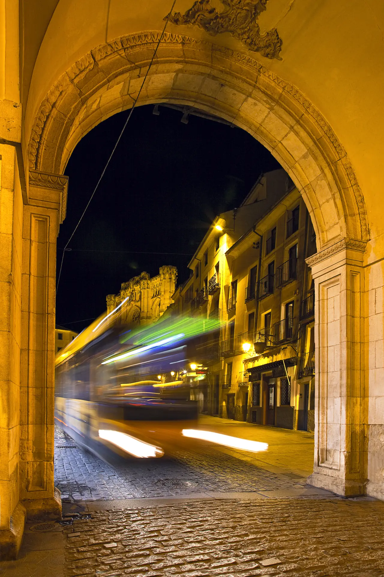 Autobús urbano de Cuenca entrando de noche en la Plaza Mayor bajo los arcos del Ayuntamiento