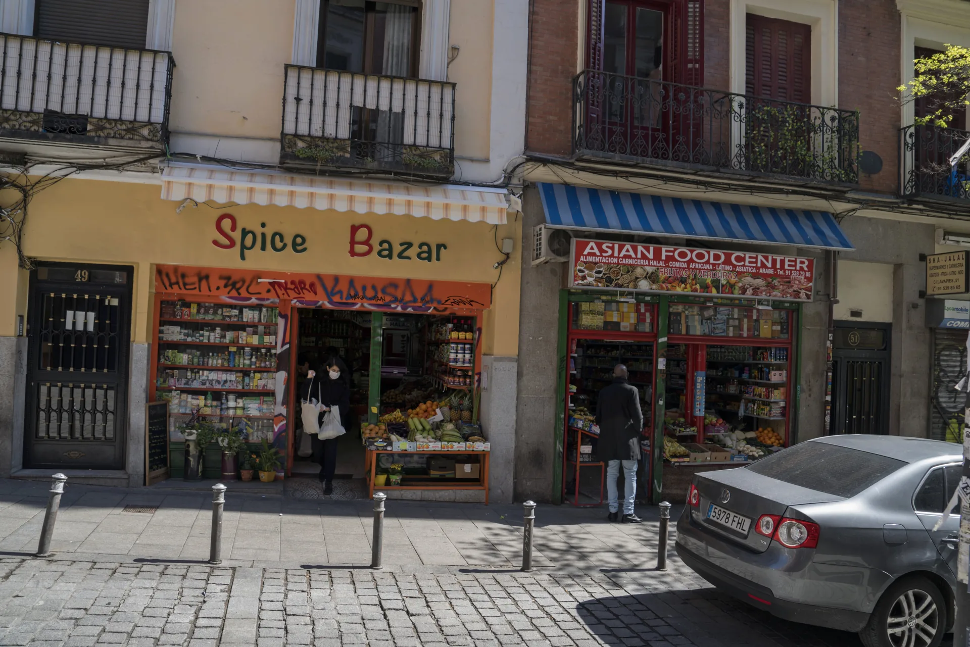 Tiendas de alimentación y especias en la calle de Lavapiés de Madrid, con balcones de hierro en las fachadas