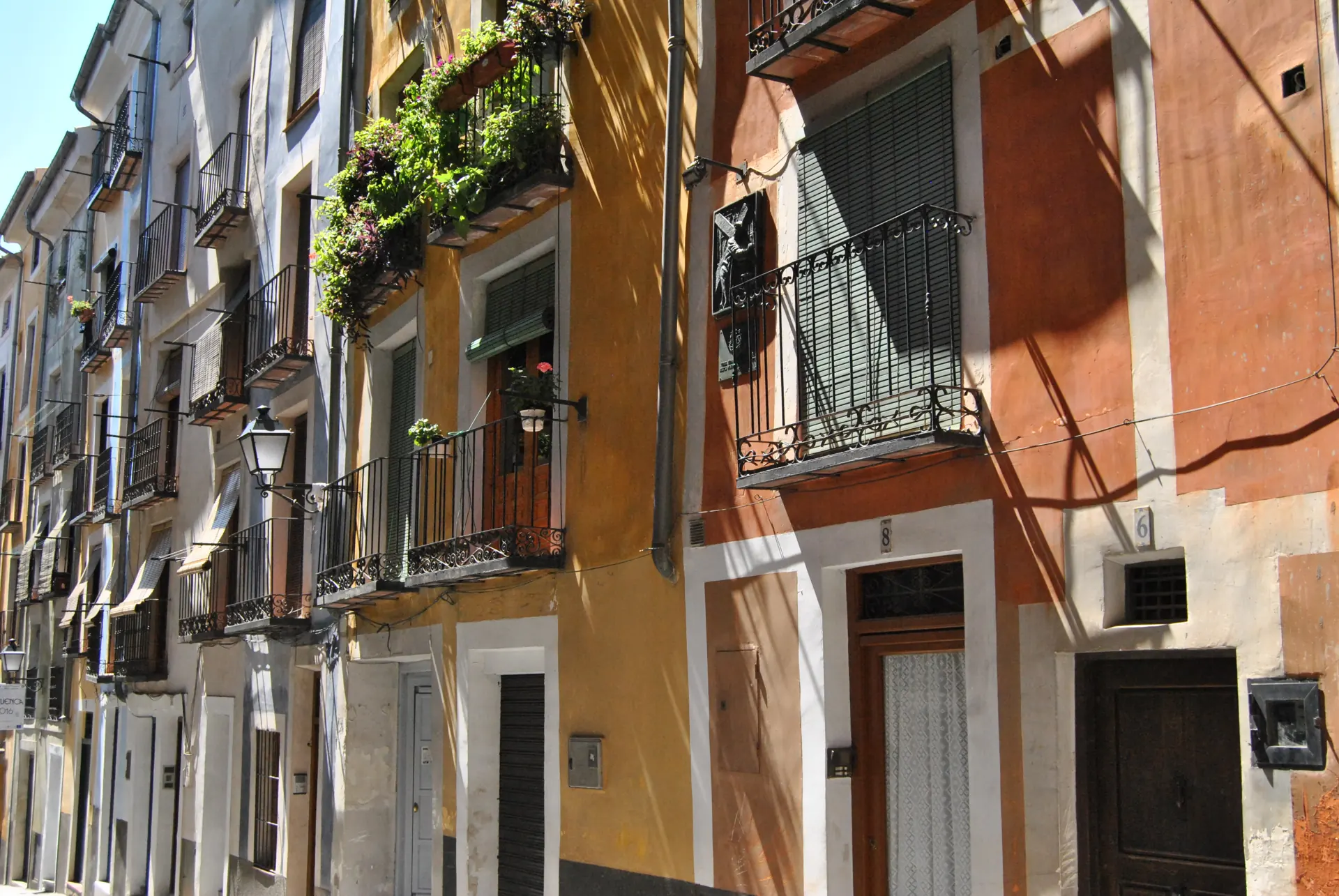 Calle Alfonso VIII de Cuenca con sus fachadas de colores y balcones de forja; bajo esta calle corre el túnel de la Guerra Civil