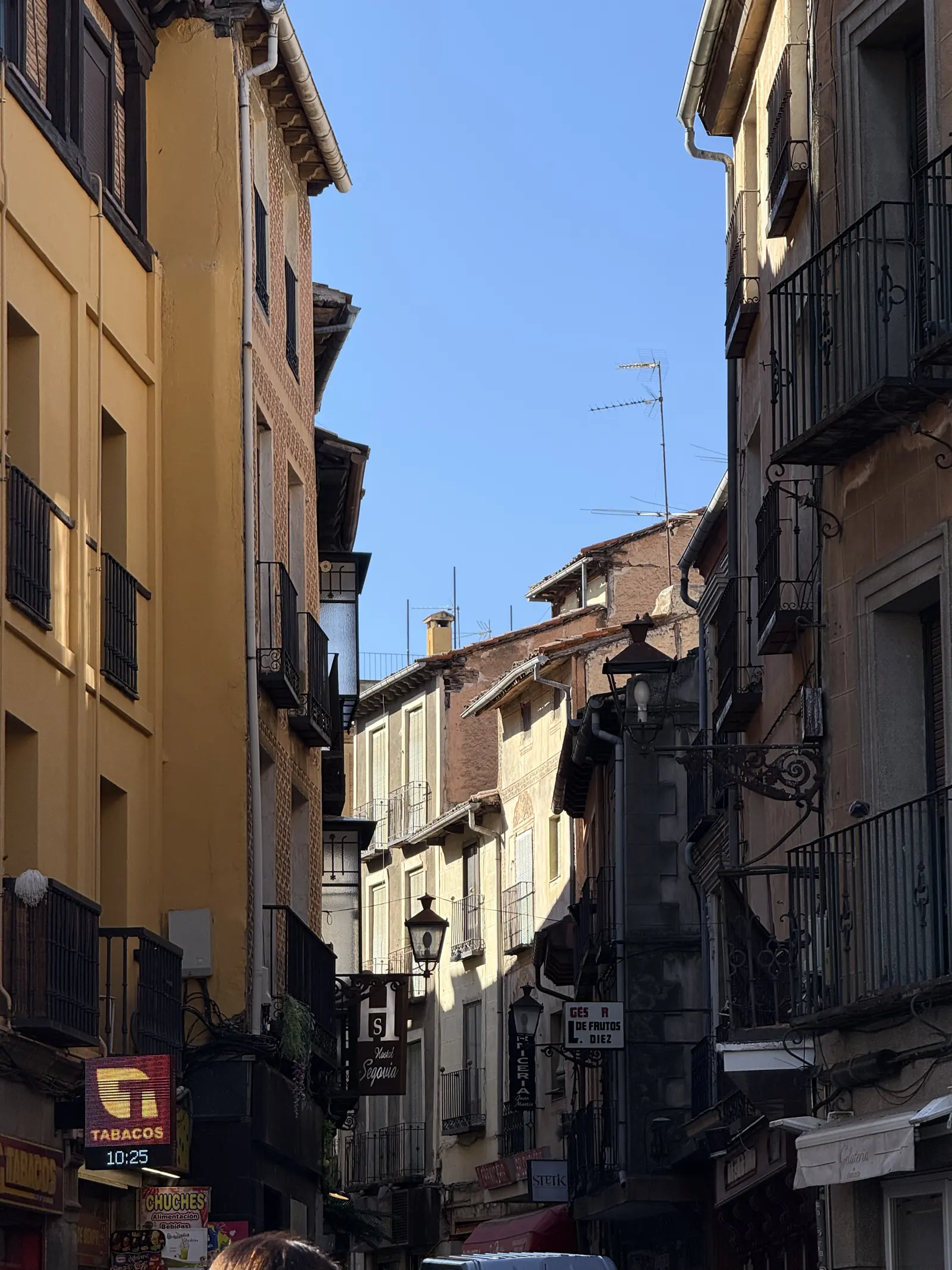 Calle estrecha del casco historico de Segovia con balcones de forja y rotulos de tiendas. Foto propia La Maleta Inquieta, octubre 2026