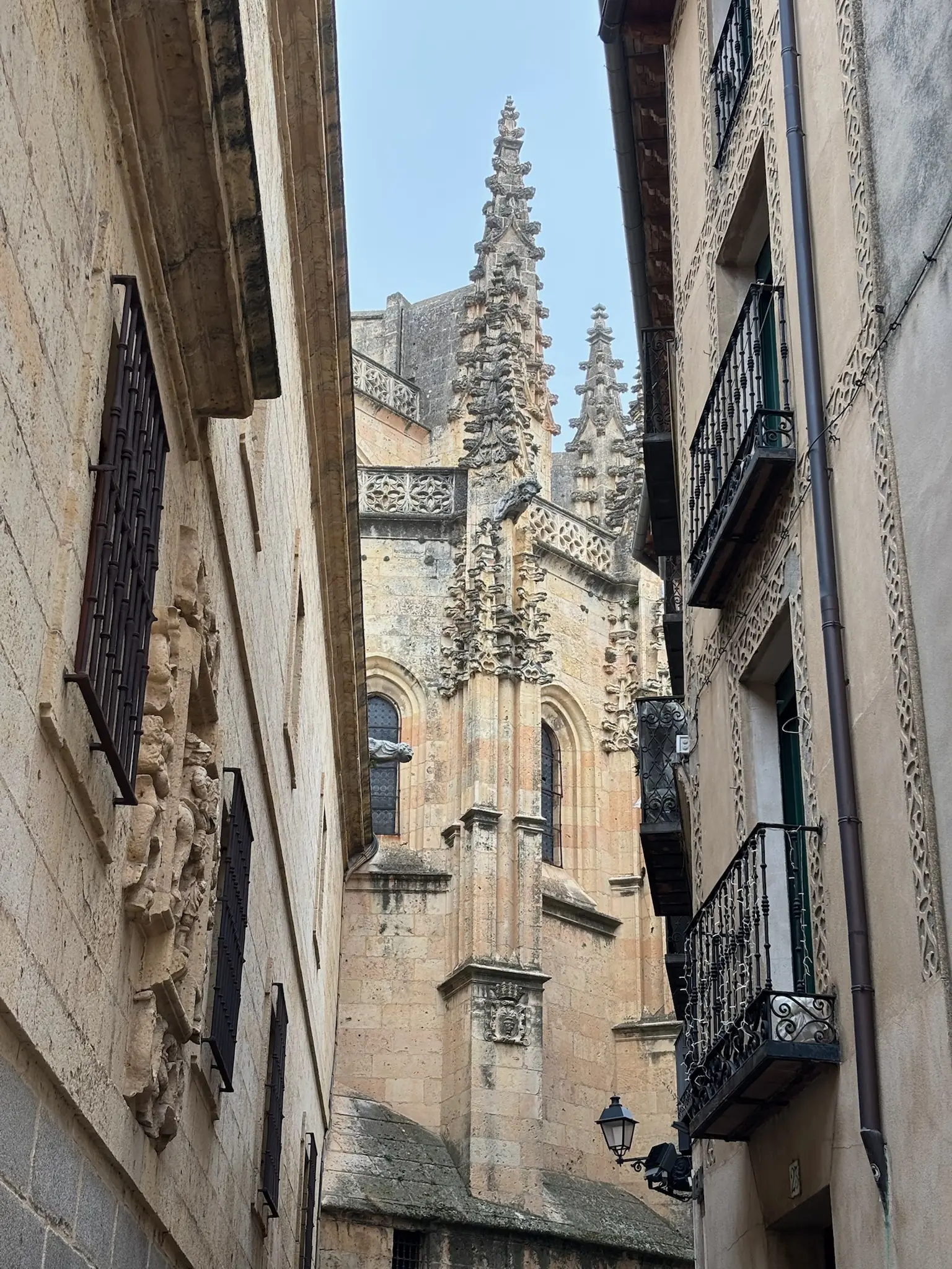 Calle estrecha del casco de Segovia con balcones y los pináculos góticos de la catedral asomando. Foto propia La Maleta Inquieta, septiembre 2026.
