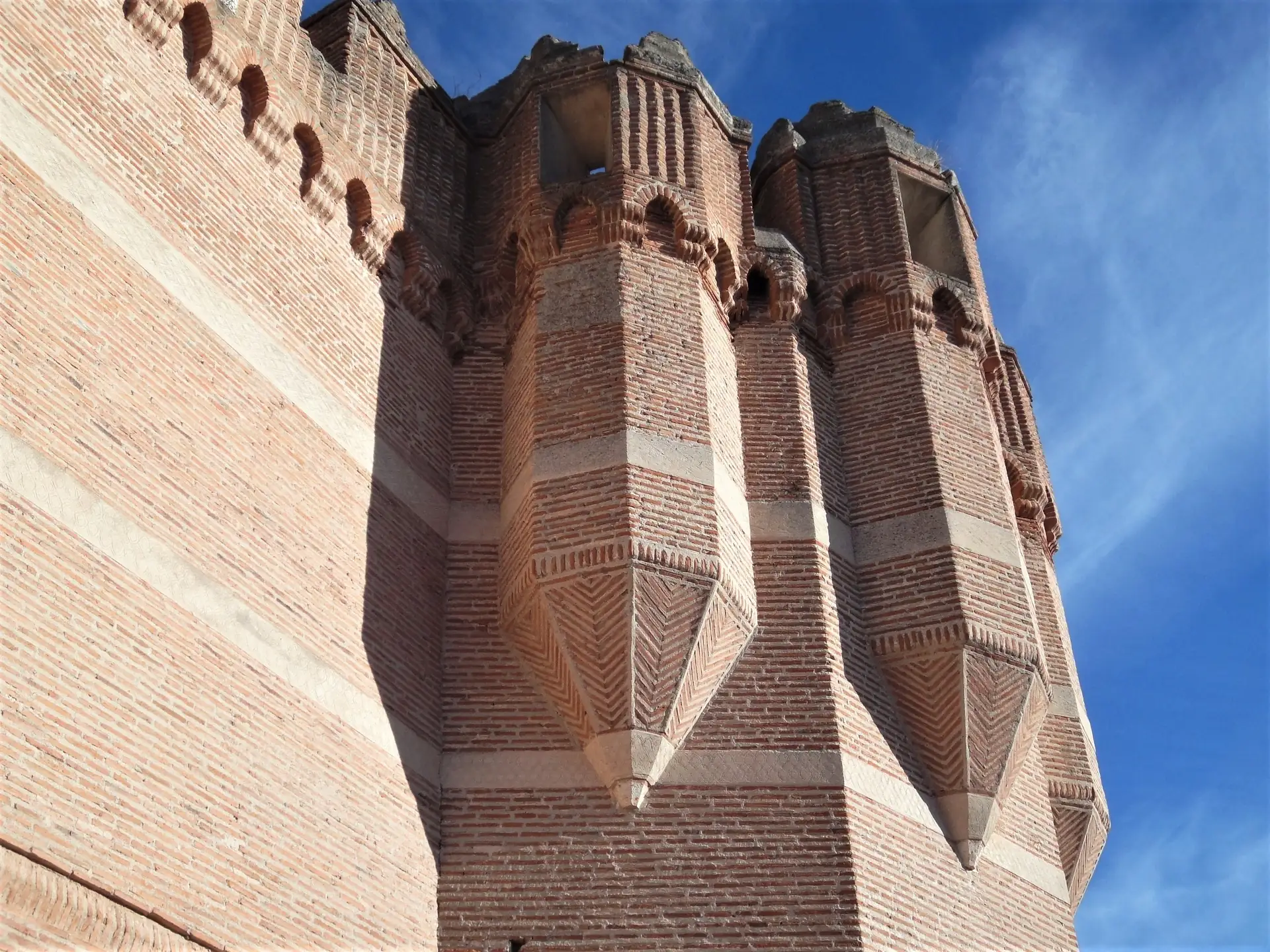Detalle del muro de ladrillo mudejar del castillo de Coca, con los lazos y arquillos decorativos.