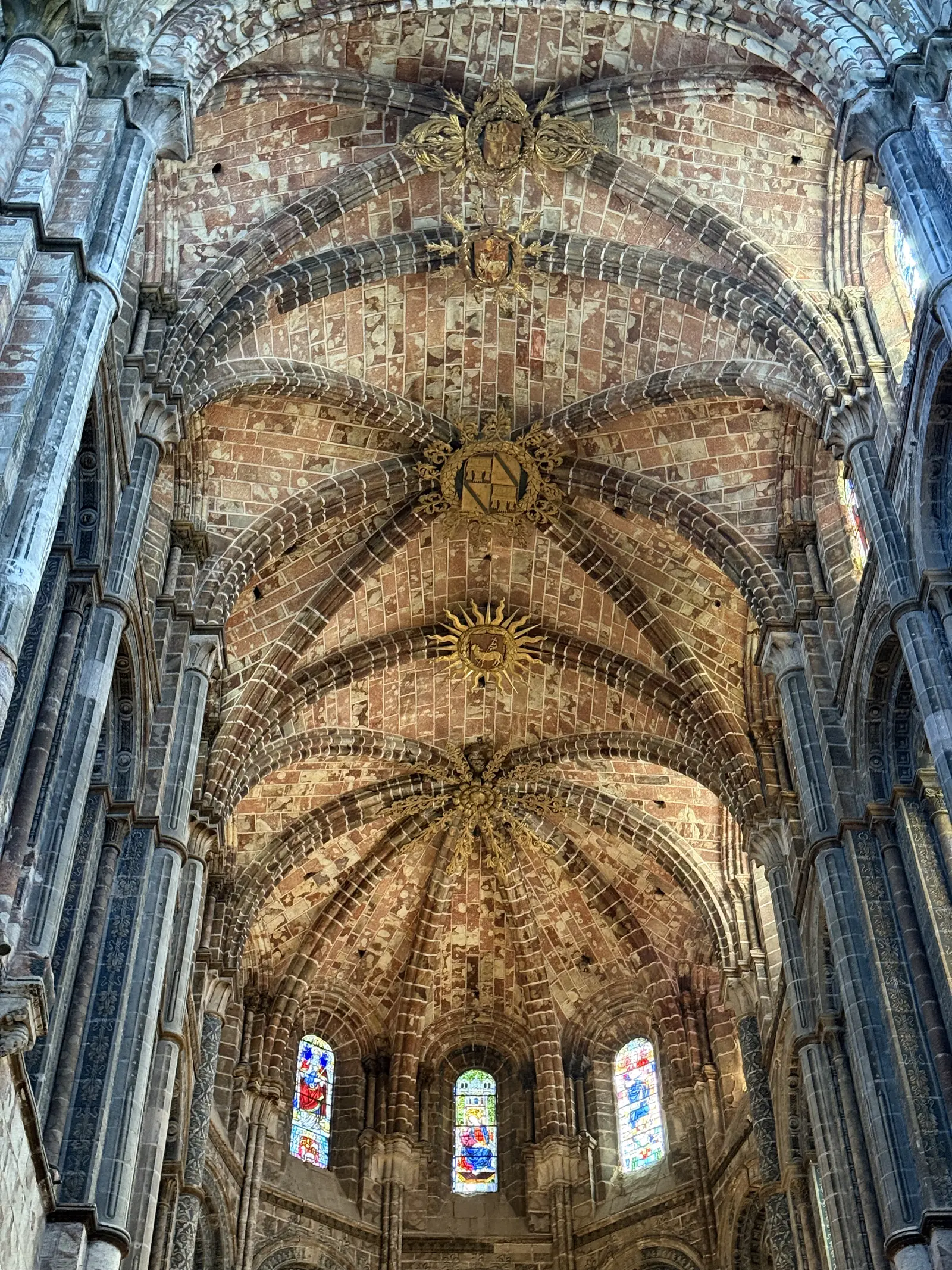 Bóvedas de la capilla mayor de la catedral de Ávila en piedra sangrante, con claves heráldicas y un sol dorado. Foto propia La Maleta Inquieta, septiembre 2026.