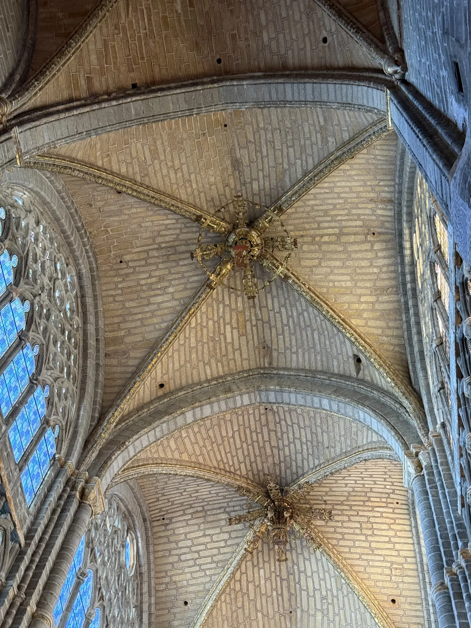 Bóvedas de crucería con claves doradas en el crucero de la catedral de Ávila, junto a vidrieras azules. Foto propia La Maleta Inquieta, septiembre 2026.