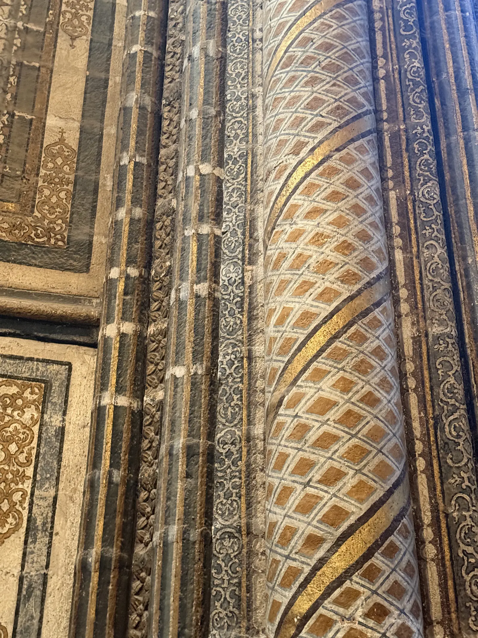 Pilar de la catedral de Ávila con decoración pintada en retícula dorada en espiral y cenefas vegetales. Foto propia La Maleta Inquieta, septiembre 2026.