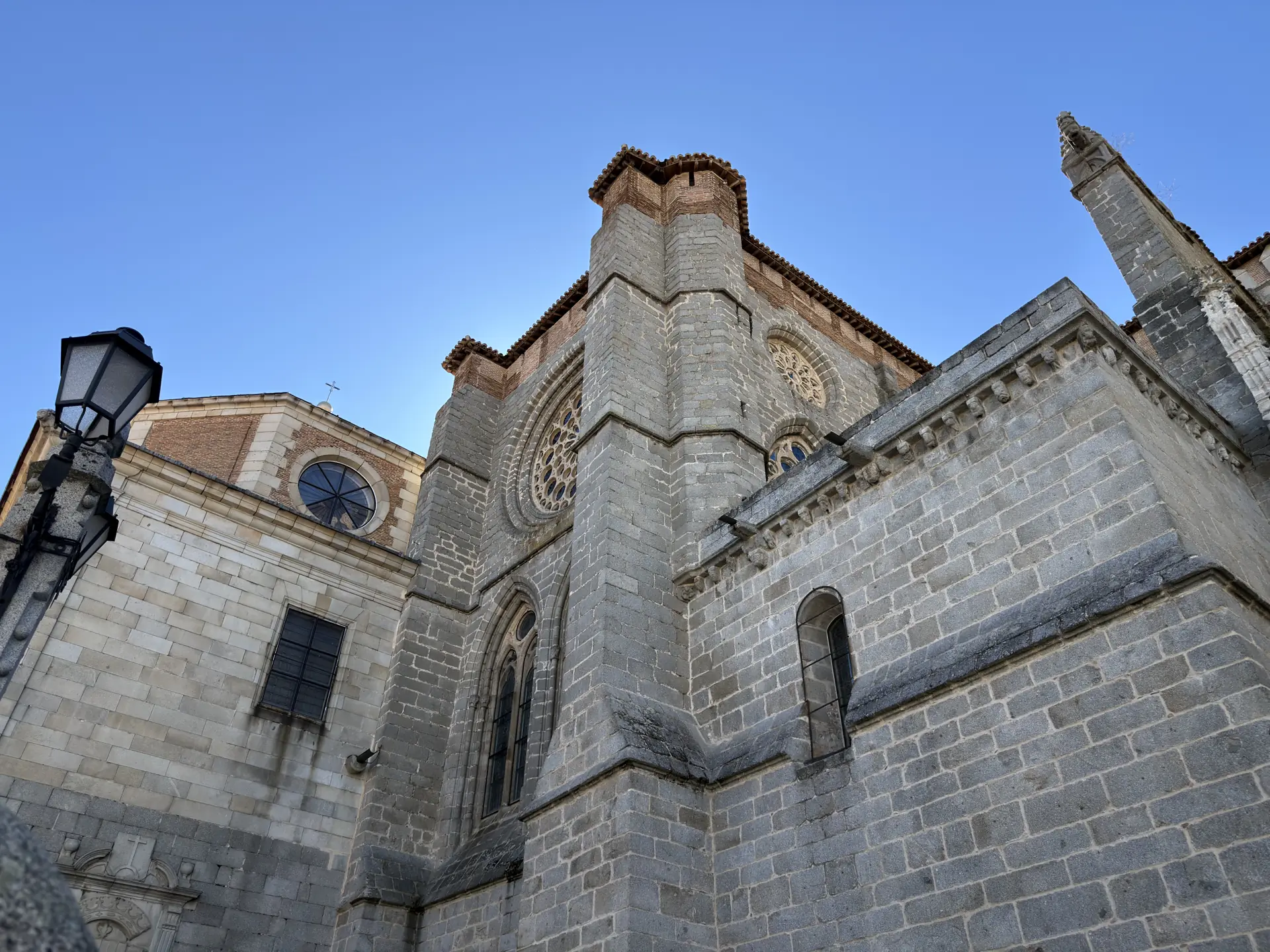 Muros de granito de la catedral de Ávila en contrapicado, con rosetones góticos y una capilla adosada con óculo. Foto propia La Maleta Inquieta, septiembre 2026.