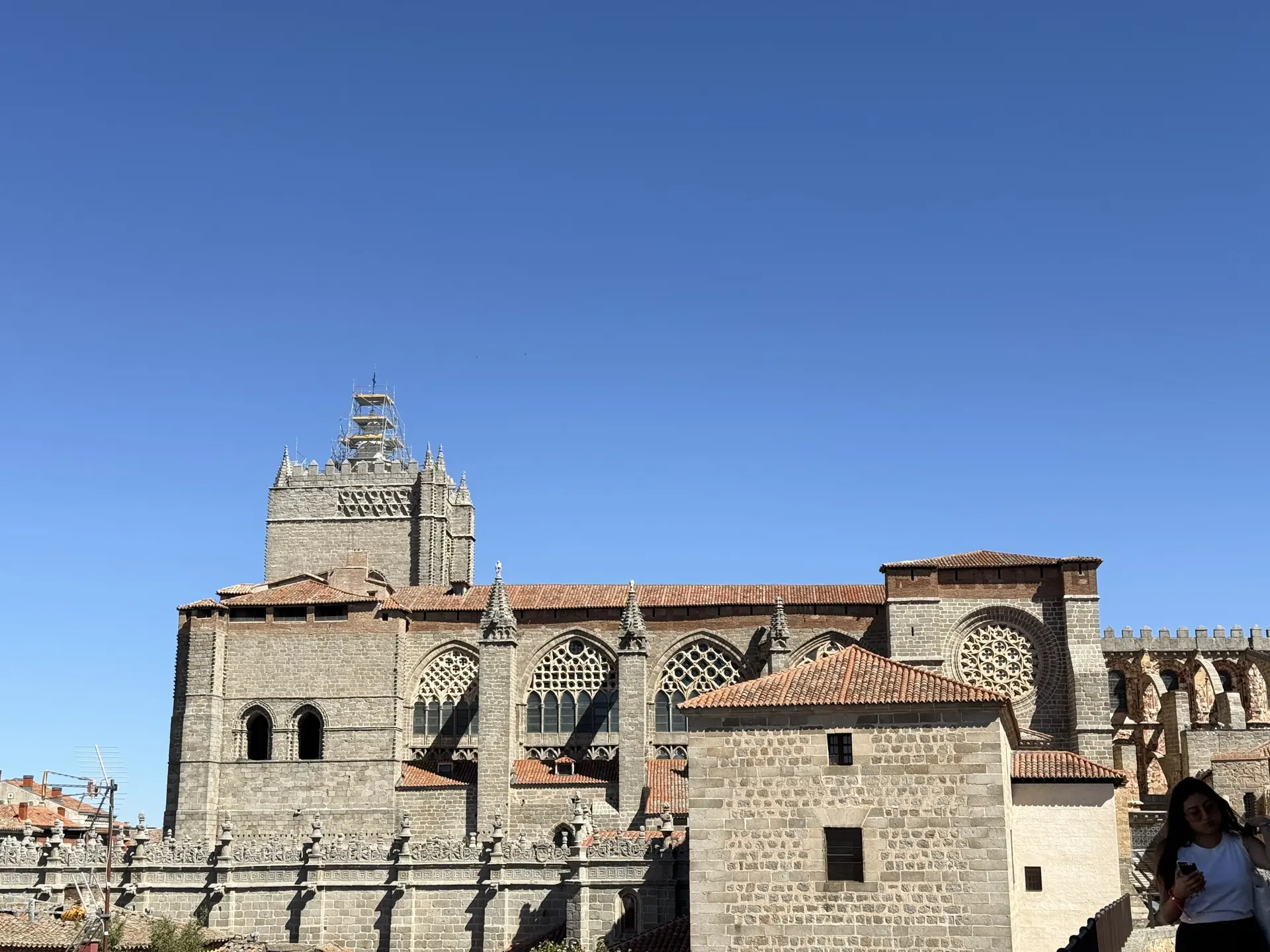 Costado sur de la catedral de Ávila con tracerías góticas, rosetón y torre en andamios, visto desde el adarve. Foto propia La Maleta Inquieta, septiembre 2026.