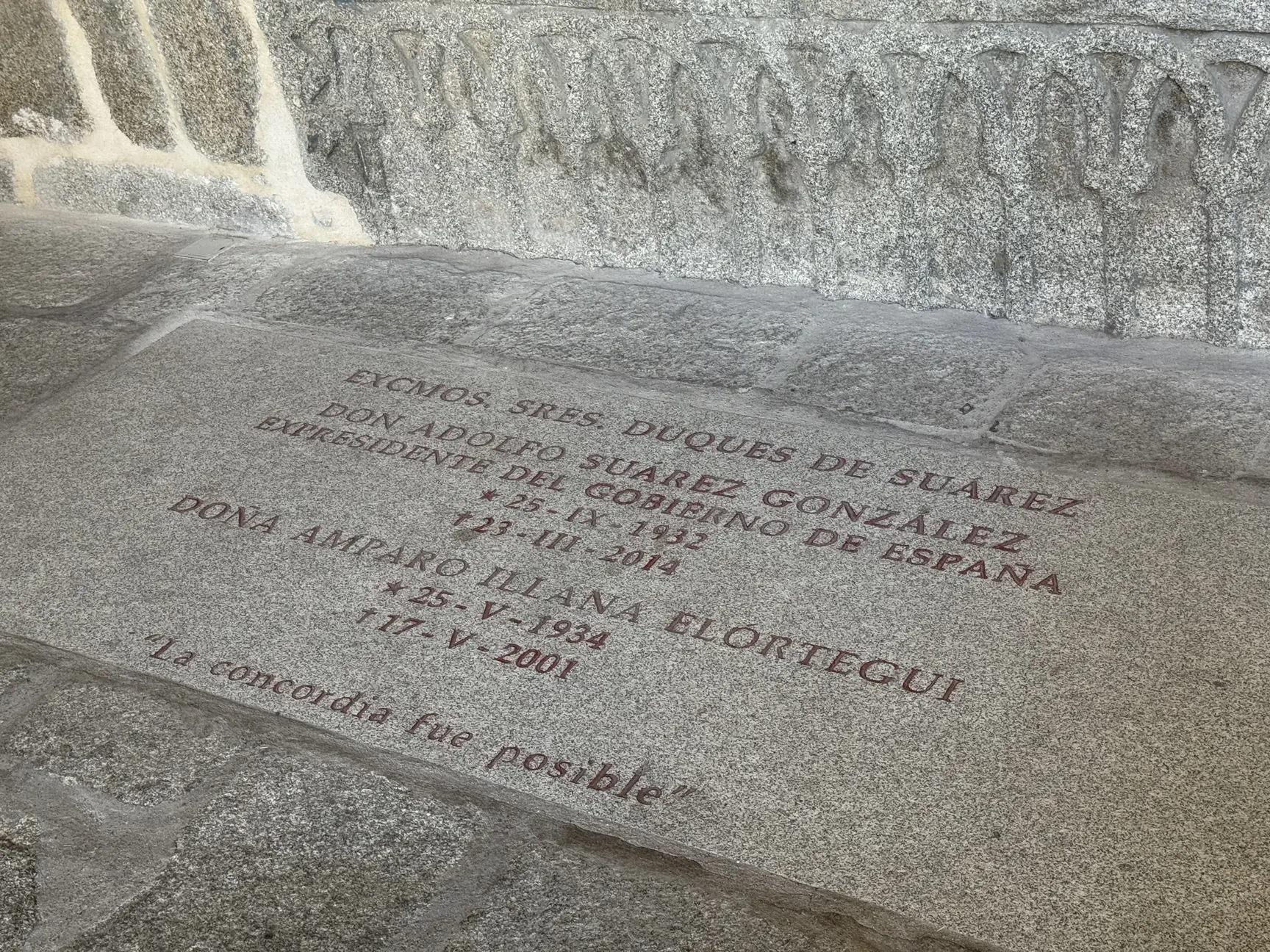 Lápida de Adolfo Suárez y Amparo Illana en el suelo del claustro de la catedral de Ávila, grabada en rojo. Foto propia La Maleta Inquieta, septiembre 2026.
