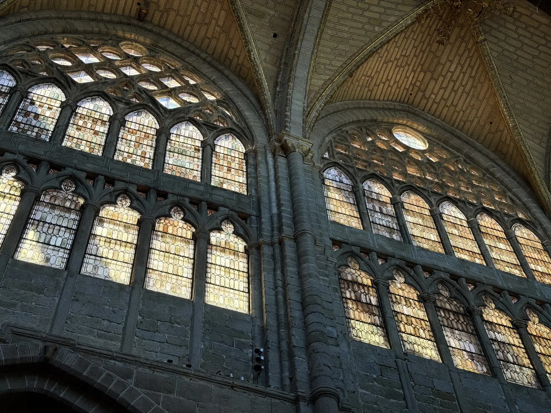 Ventanales góticos de doble cuerpo con vidrieras ocres a contraluz en los muros altos de la catedral de Ávila. Foto propia La Maleta Inquieta, septiembre 2026.