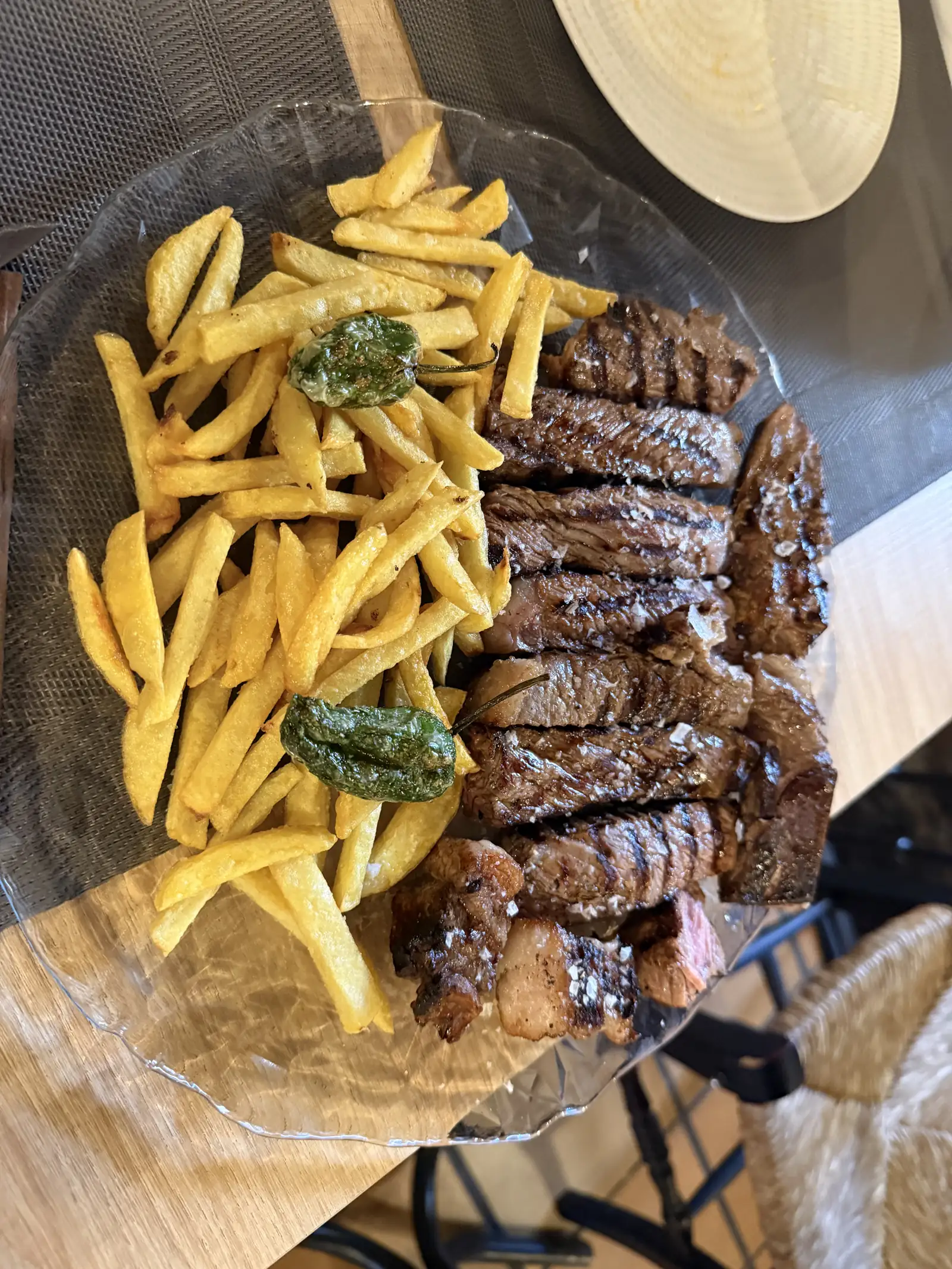 Chuletón de Ávila fileteado con patatas fritas y pimientos de Padrón en Redes Bar, servido en un plato de cristal. Foto propia La Maleta Inquieta, septiembre 2026.