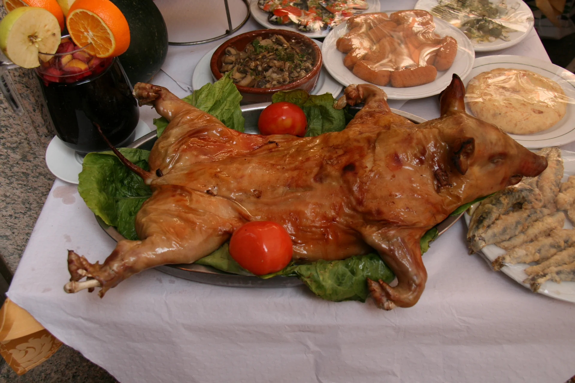 Cochinillo asado servido entero en la mesa, con la piel dorada, el plato estrella de Segovia.