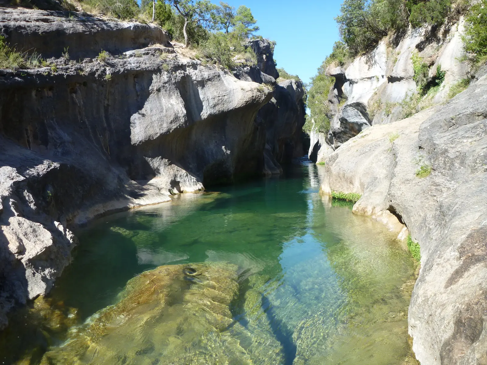 Poza de agua verde y transparente del río Júcar entre paredes de roca en los Cortados de Villalba de la Sierra