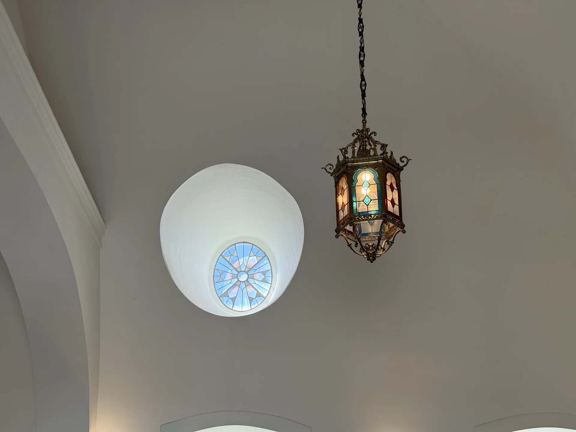 Cúpula interior con tragaluz circular de vidriera azul y lámpara de forja con vidrieras de colores, Foto propia La Maleta Inquieta, septiembre 2026
