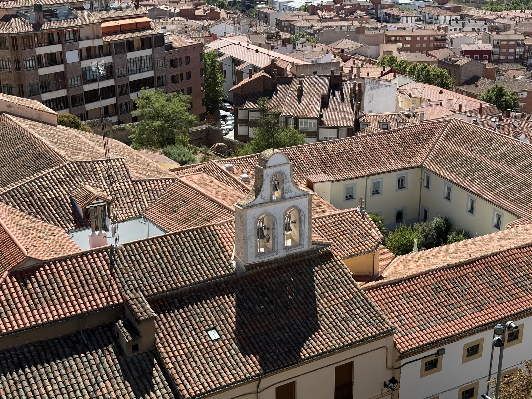 Espadaña blanca con dos campanas y patio de un convento junto a la plaza de Santa Teresa, desde la muralla. Foto propia La Maleta Inquieta, septiembre 2026.