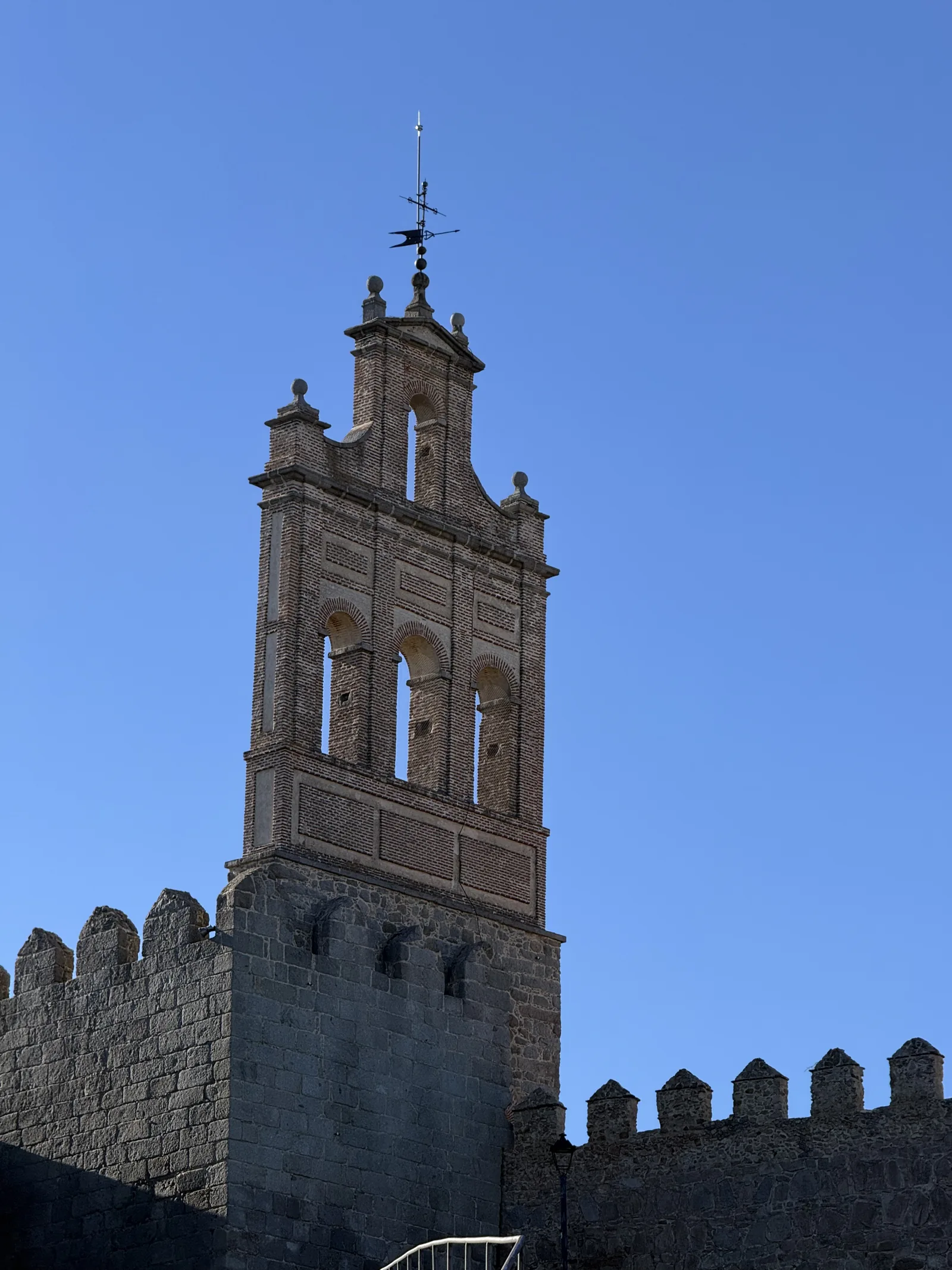 Espadaña barroca de ladrillo con veleta sobre la torre de la Puerta del Carmen, en el lienzo norte de Ávila. Foto propia La Maleta Inquieta, septiembre 2026.