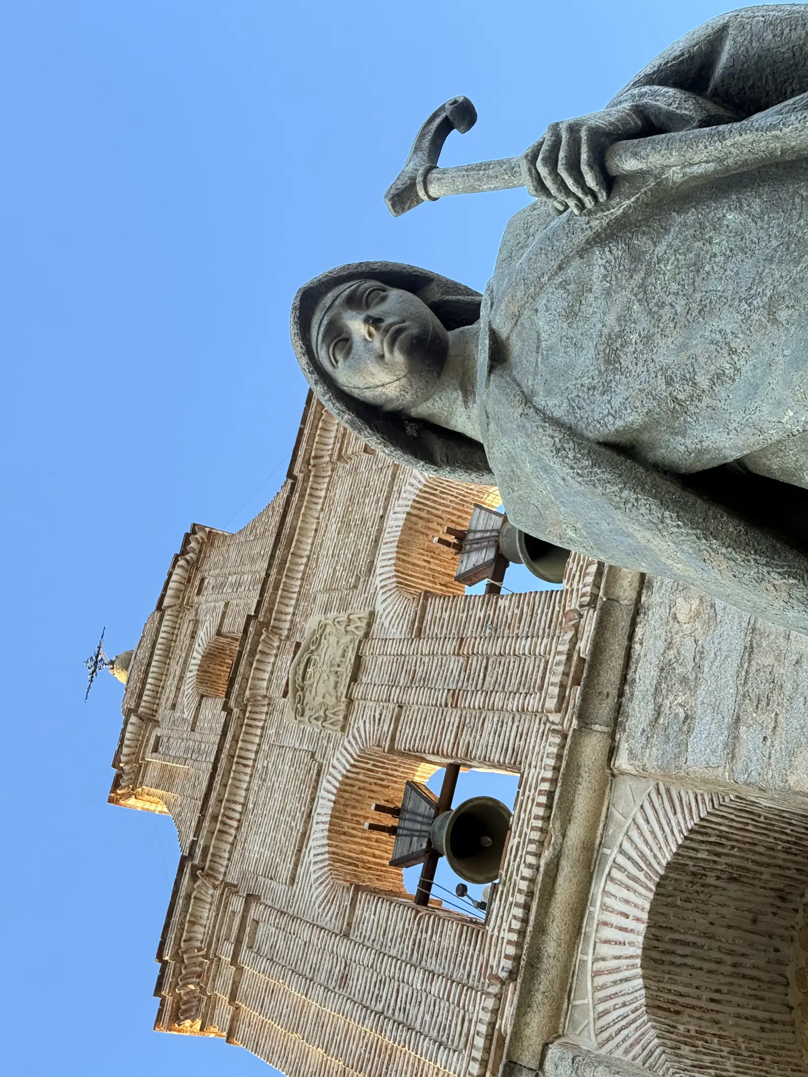 Estatua de Santa Teresa con bastón vista desde abajo bajo la espadaña del monasterio de la Encarnación de Ávila. Foto propia La Maleta Inquieta, septiembre 2026