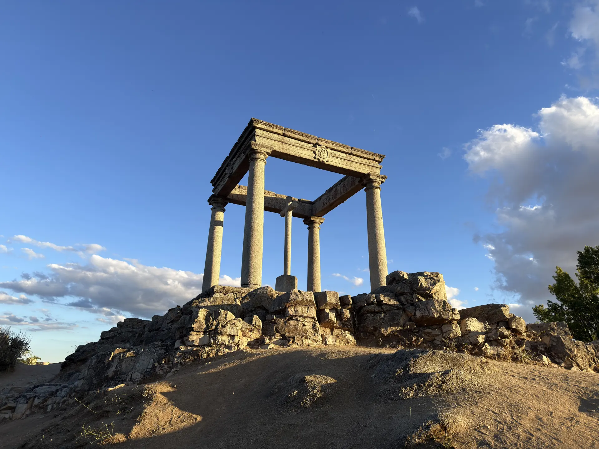 Humilladero de Los Cuatro Postes de Ávila sobre su peña de granito, visto desde abajo con luz de tarde. Foto propia La Maleta Inquieta, septiembre 2026
