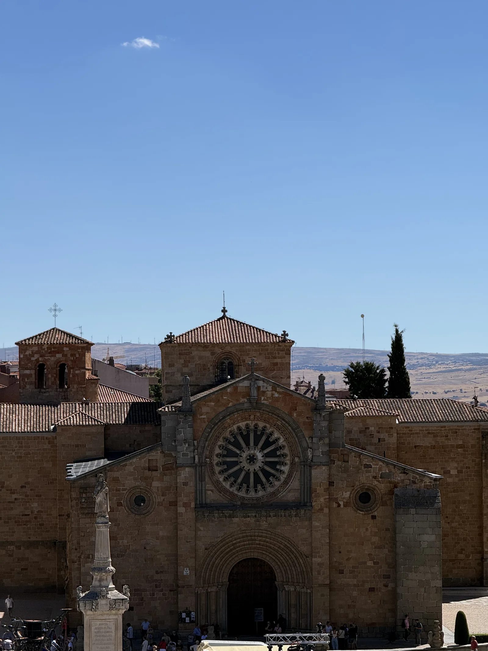 Rosetón y portada de San Pedro de Ávila vistos desde la muralla, con la columna de Santa Teresa delante. Foto propia La Maleta Inquieta, septiembre 2026.