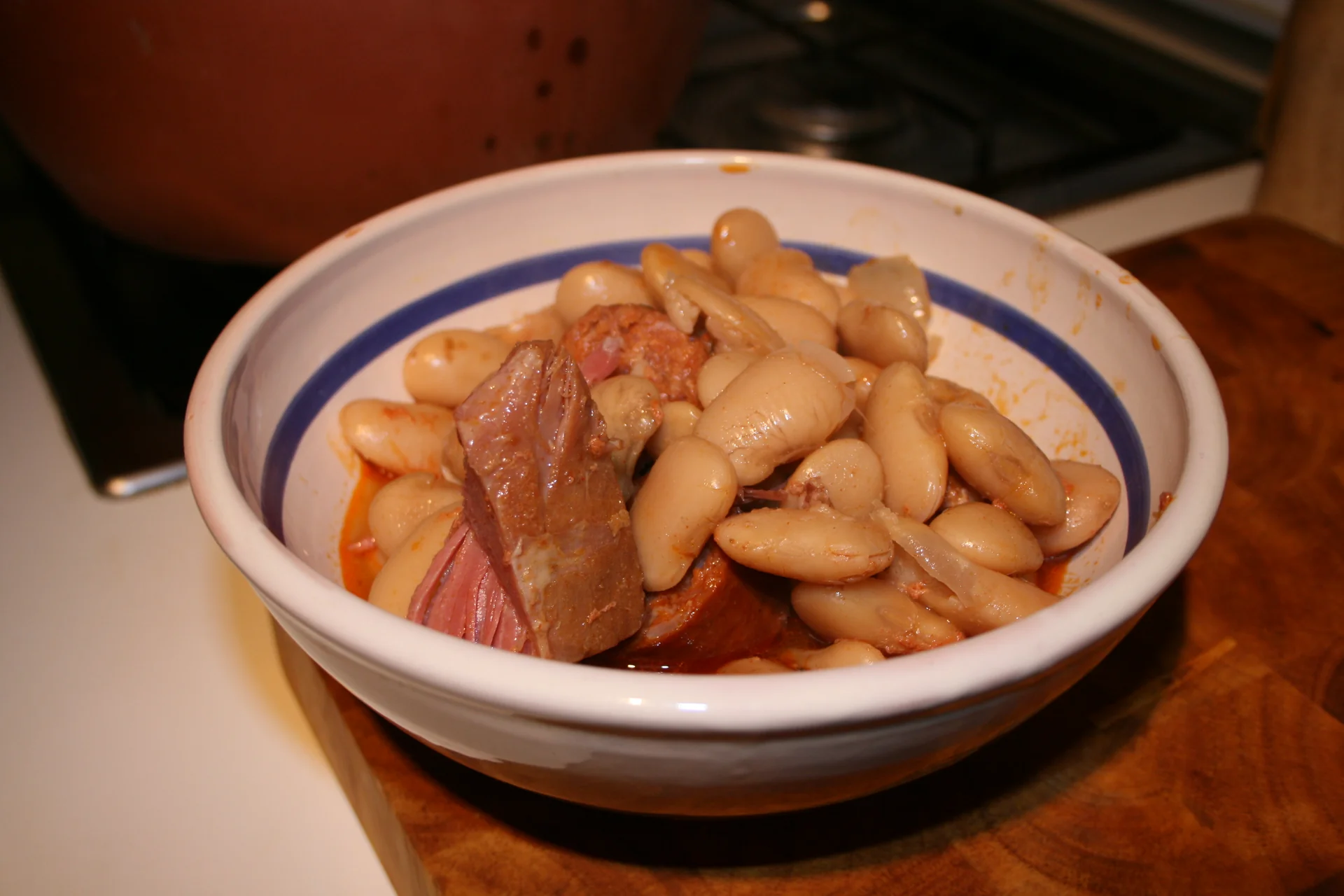 Plato de judiones de La Granja guisados con chorizo y oreja, servido en cuenco de ceramica.