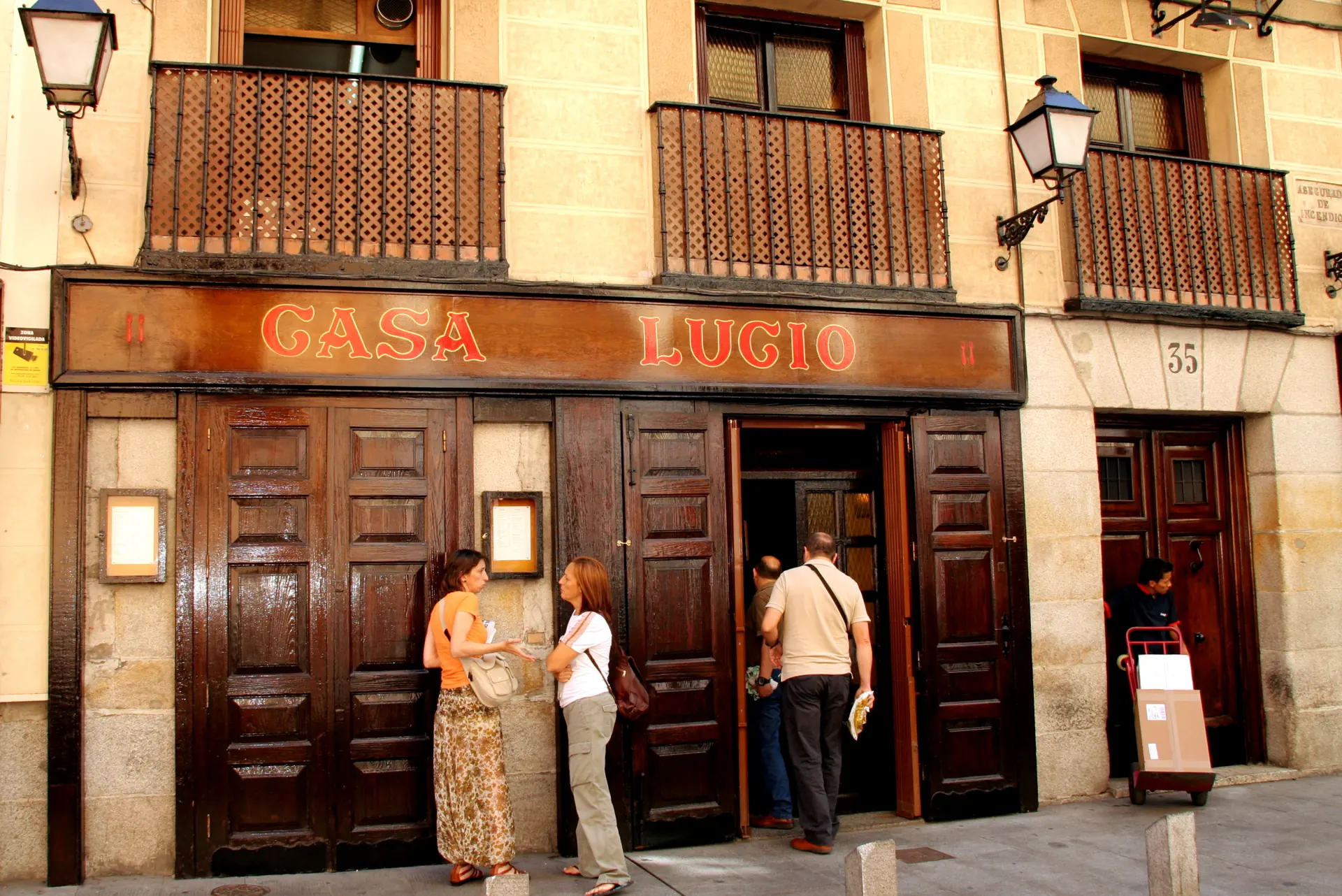 Fachada de madera de Casa Lucio, en el número 35 de la Cava Baja de Madrid, con gente entrando al restaurante