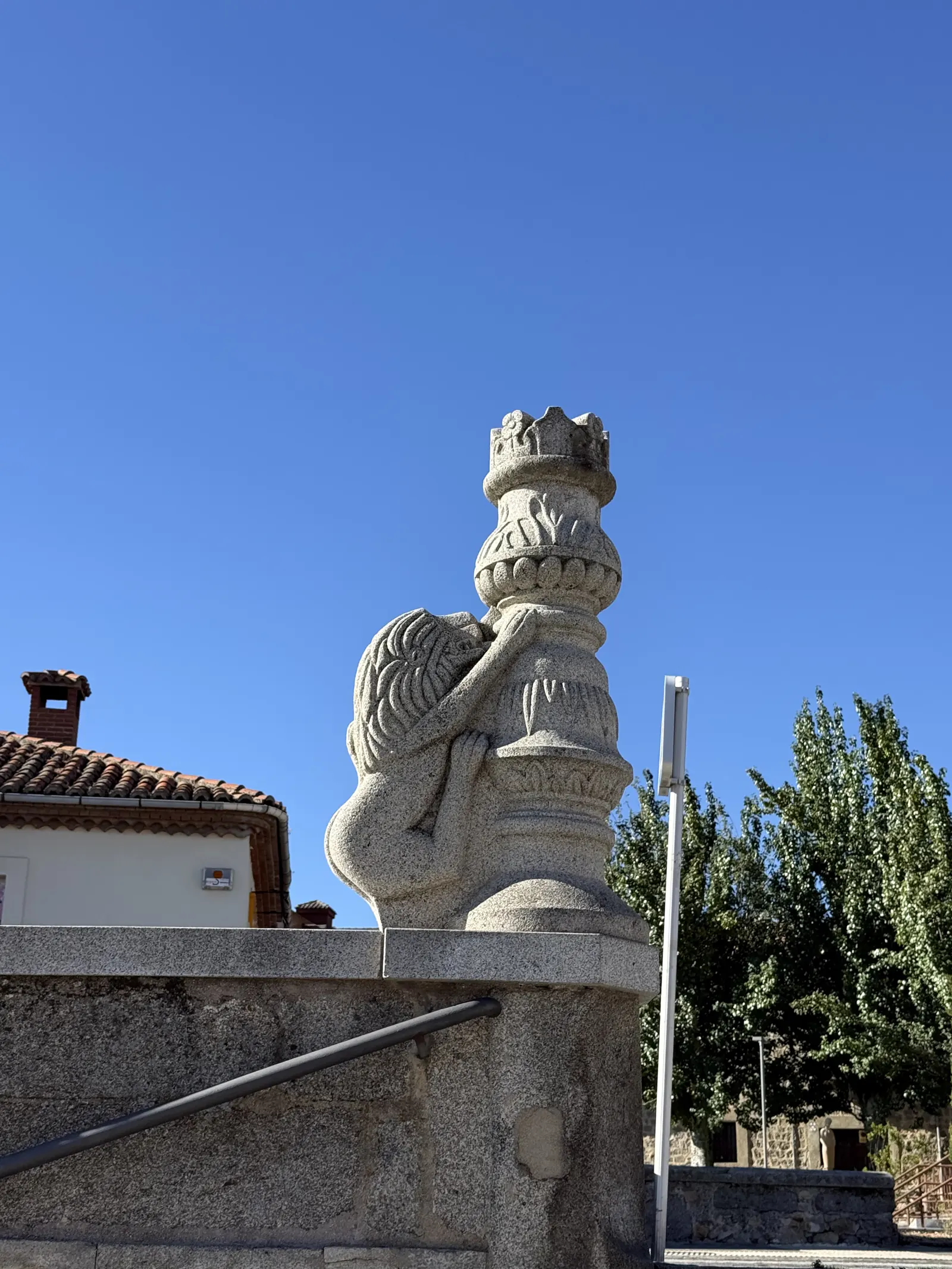 León de granito abrazado a un remate coronado sobre el pretil de una escalinata cerca de San Vicente de Ávila. Foto propia La Maleta Inquieta, septiembre 2026.