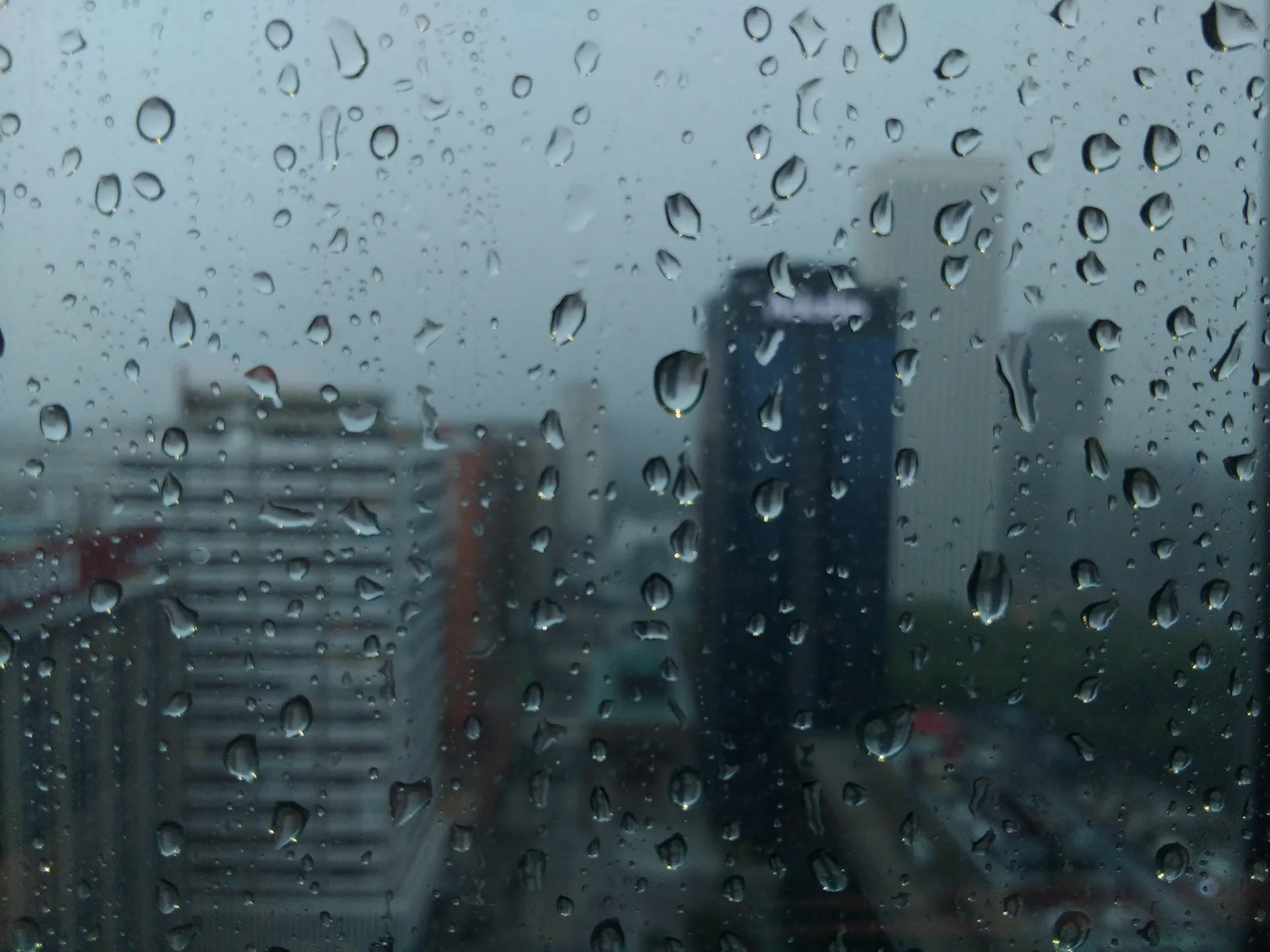 Gotas de lluvia en un cristal con edificios de Madrid al fondo