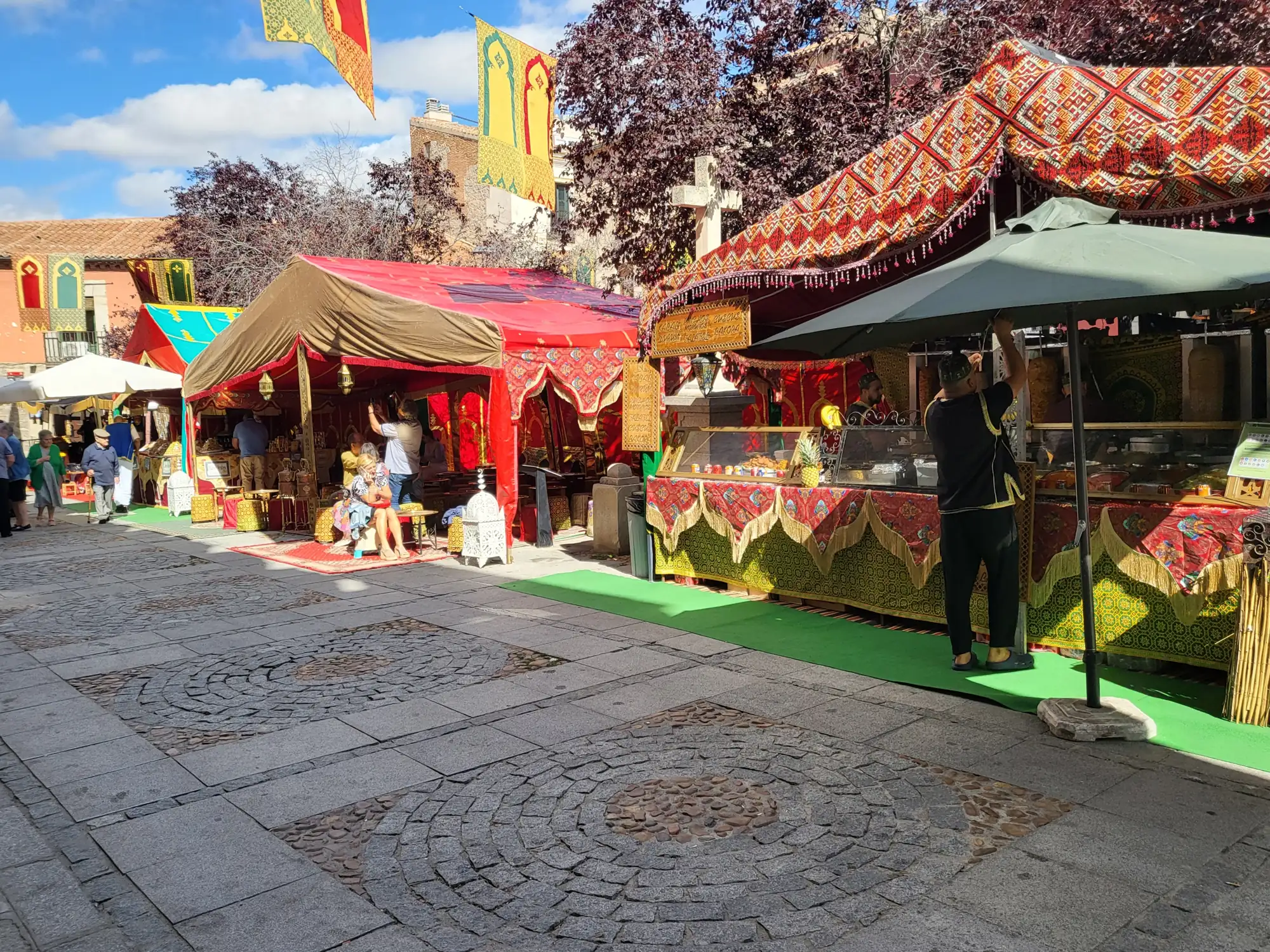 Puestos con toldos rojos y adornos medievales en una calle del casco histórico de Ávila
